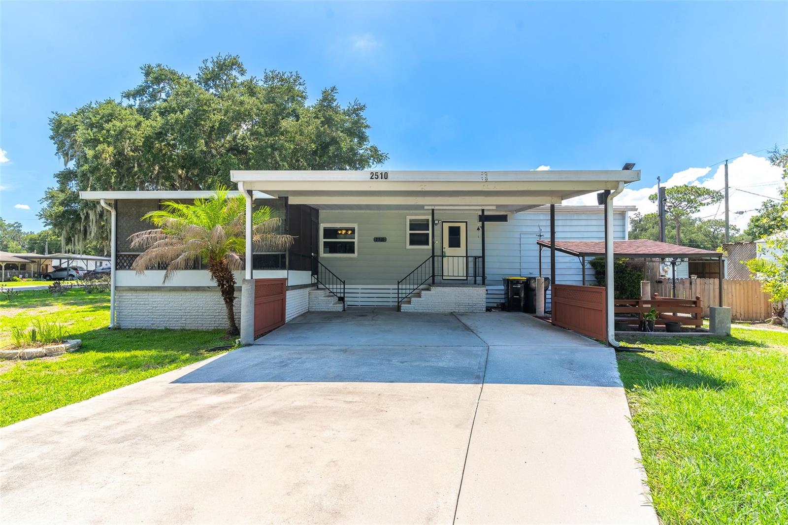 Virtually Staged. Welcome home to this beautifully maintained 2-bedroom, 2-bath manufactured home offering spacious living, tasteful updates, and exceptional outdoor amenities on a fully fenced corner lot. Pride of ownership shines throughout this move-in-ready property, delivering comfort, functionality, and plenty of room to enjoy the Florida lifestyle.
Step inside to an inviting open-concept floor plan where the kitchen, dining, and living areas flow seamlessly together, creating the perfect setting for both everyday living and entertaining. Vaulted ceilings and abundant natural light give the home a bright, airy feel, while updated high-efficiency windows provide energy savings and year-round comfort.
The tastefully updated kitchen features modern finishes, ample cabinetry, and new stainless steel appliances, offering both style and practicality for any home chef.
The oversized primary suite is a true retreat, featuring a massive walk-in closet and a private ensuite bathroom complete with a walk-in shower and extensive built-in cabinetry for exceptional storage. The spacious secondary bedroom also boasts its own large walk-in closet and is conveniently located near the home's second full bathroom, providing comfort and privacy for family members or guests.
A generous walk-in laundry room with built-in cabinetry adds even more storage and convenience, keeping everything organized and within easy reach.
Enjoy Florida living year-round from both the expansive screened front lanai and the additional screened rear lanai, offering multiple spaces to relax, entertain, and enjoy the outdoors in comfort.
Situated on a fully fenced corner lot, the property provides outstanding flexibility with two separate driveways and two access points, making it ideal for storing additional vehicles, a boat, RV, or trailer with ease. A large two-car carport, multiple sheds, workshops, and lean-to storage areas create endless possibilities for hobbyists, gardeners, craftsmen, or anyone needing exceptional space for tools and equipment.
Best of all, there is no HOA, giving you the freedom to enjoy your property without restrictive rules or fees. Conveniently located in Lakeland, you'll have quick access to downtown dining, shopping, everyday conveniences, and major highways for an easy commute throughout Central Florida.
Combining thoughtful updates, spacious bedrooms, incredible storage solutions, RV and boat parking potential, and an unbeatable location, this meticulously cared-for home is a rare opportunity offering comfort, convenience, and endless possibilities for its next owner.
