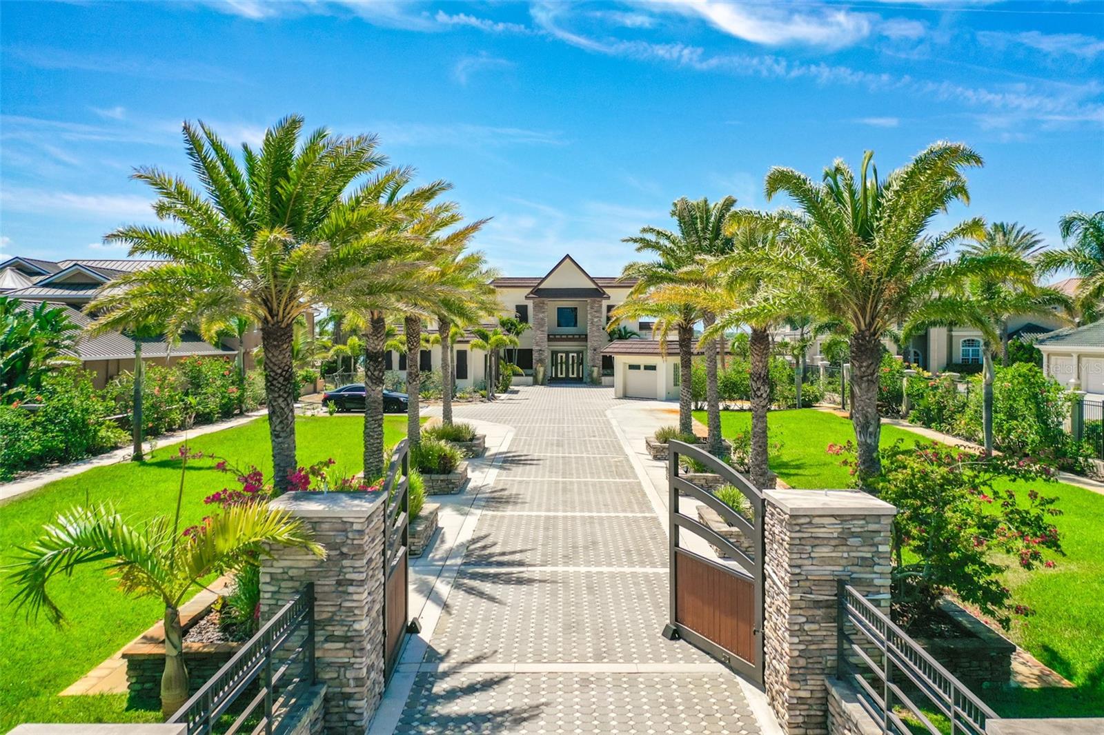 Introducing a stunning gated beachside riverfront estate, set on an expansive 1.4 acres that evoke a park-like atmosphere, located just minutes from the beautiful shores of Daytona Beach. This custom-built luxury home boasts an impressive 4,985 square feet of living space, featuring three spacious bedrooms, three full bathrooms, and two half baths, along with an in-law suite, an office, and a versatile loft that's perfect for family life and entertaining. Additionally, the property includes a generous four-car garage totaling 1,152 square feet. With 115 feet of waterfront access, complete with a deep-water dock, this estate offers an exceptional blend of comfort and outdoor enjoyment.

Showcasing over a million dollars in high-end upgrades. As you pass through the elegant gates, you’ll be welcomed by a sprawling paver motor court with custom stacked stones pillars. This home boasts a robust concrete block stucco exterior with striking stacked stone pillars all leading to a grand and inviting entrance. Upon entering through the double doors, you’re immediately met with a soaring 22-foot ceiling that frames expansive river views, while an exquisite crystal chandelier hangs seamlessly with understated elegance. The first floor is finished with lustrous 36x36 porcelain tiles, adding a touch of modern refinement.

Step into the chef inspired kitchen adorned with a contemporary flair highlighted with black wood cabinets, an impressive custom island, soft close drawers, and wrapped in a double slab stone countertop. Kitchen Aid appliances with two refrigerators, two dishwashers, double oven, warming drawer, and 6-burner gas stove with pot filler. The butler's pantry is tucked away for seamless hosting, equipped with a dishwasher, deep sink with disposal, and large pantry. Right off the kitchen is the spacious living room which features travertine stacked stones all the way up the wall to create a beautiful feature wall with a contemporary fireplace and tv niche. 

Ascend the custom-built walnut staircase, adorned with wrought iron balusters, to discover the upper level encompassing 1,283 square feet of exquisite living space. The primary bedroom offers breathtaking river views, complete with a private deck that overlooks the pool. The primary bath exudes luxury, featuring a relaxing soaking tub, a walk-in shower with striking tile that elegantly extends up the wall, a separate toilet and bidet in the water closet, and a spacious walk-in closet. Additionally, the upper level includes a stunning loft.

Downstairs, you'll find a riverfront bedroom that features a cozy in-law suite, complete with a private living room and a well-appointed laundry room, equipped with ample cabinetry and two washing machines and dryers for added convenience. The full bathroom showcases rustic charm, featuring a thoughtful mix of gray, brown, and beige tiles that evoke a farmhouse aesthetic. Additionally, the third bedroom comes with its own ensuite bathroom.

The inviting backyard is highlighted by a lovely pool, added in 2017, which is perfect for relaxation or entertaining guests, a large pergola, and walkways in a serene setting. The 2019 sea wall provides added protection and stability, enhancing the property’s value and appeal. For those who enjoy boating, this property is an entertainer's dream. Square footage received from tax rolls. All information intended to be accurate but cannot be guaranteed.