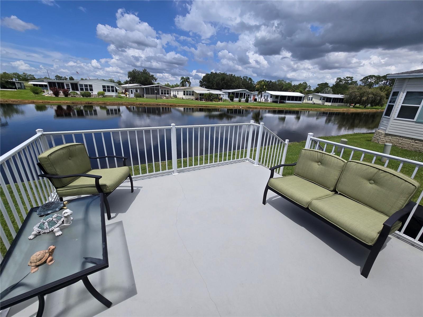 ON THE POND WITH A VIEW! Own your land and run your own life as this is a community owned by the residents and we make the decisions (I live here!) The HOA includes everything except your electric bill and lawn mowing! This beauty provides entertainment by all the nature you get a birds-eye view of from your kitchen, back patio, and the Florida Room. The floors are all laminate, the rooms are well sized, lots of storage with a pantry and 2 linen closets. The Primary Bedroom has an en suite bathroom and the closet is 4'deep! The bedrooms enjoy a split floor plan so everyone has more privacy. Laundry is in the kitchen by the dinette area. The Florida Room, on the AC, adds to your living space! The AC was replaced in 2017, the water heater in 2024, Main Roof in 2022 (vents redone in 2023), and the Florida room and carport roof was installed in 2023.  The entire plumbing system for the  whole house was just completely redone! This financially sound, gated golf community has structured itself to enjoy the good life! The golf cart is included so you are ready to enjoy the executive 18 holes golf course for just $5 green fees in this Gated, Golf Community, located just outside of the city, and approx. 1.25 hrs. from either coast. Great access to Disney, Legoland, and BOK Tower, just to name a few local attractions. In this very friendly, resident-owned community, you can be as active or inactive as you choose! Gatherings at the private Pub or the Community Room, fishing & boating on Lake Henry (dock within the community), gardening, tennis, golf, shuffleboard, pickle ball, horseshoes, swimming in the heated pool, enjoy the hot tub or the 24/7 workout room! Contact this community's website for documents, including Rules/Regs, Application, Financial, and Bylaws. HOA INCLUDES A DVR PLUS 2 HD CABLE BOXES AND INTERNET! (Minimum age in this 55+ community is 50 years old)