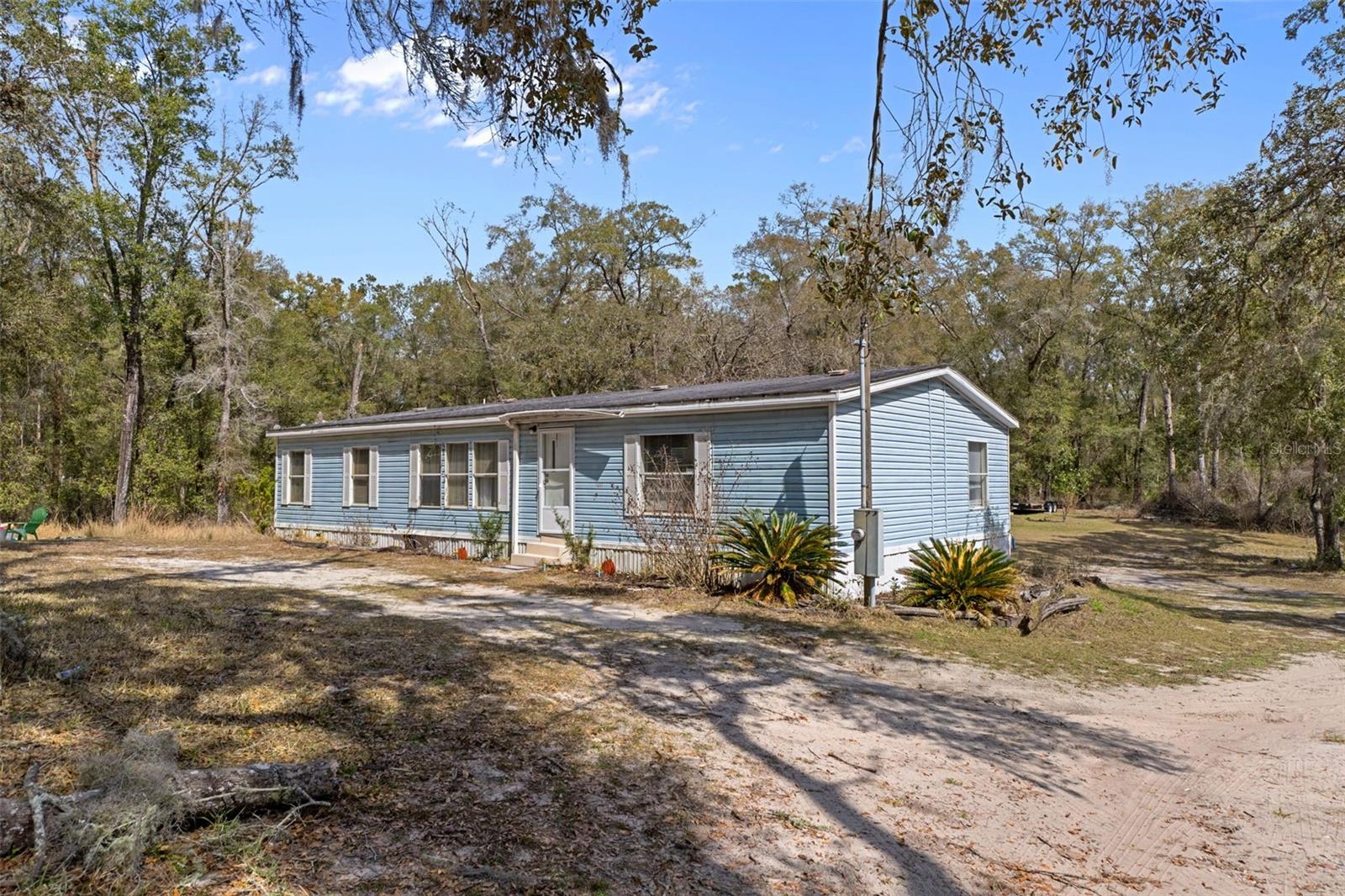 Welcome to your own private retreat! This spacious 3-bedroom, 1.5-bath double-wide home sits on approximately 6.03 acres, offering the perfect blend of peaceful country living with convenient access to nearby amenities. Inside, you’ll love the desirable split floor plan, providing added privacy for the primary bedroom. All three bedrooms feature walk-in closets, giving everyone plenty of storage space. Recent improvements, per the seller, include new plumbing installed in 2021, a water softener added in 2021, a new well and AC with heat pump installed in 2024, adding peace of mind for the next owner. Step outside and enjoy the wide-open space—ideal for gardening, animals, recreational vehicles, or simply soaking in the natural surroundings. The property is mostly fenced and features a gated entrance for added privacy. A shed purchased in 2025 offers excellent additional storage for tools and equipment. Enjoy the convenience of being just minutes from I-75, US 301, and SR 50, making travel to Orlando, Tampa, and Ocala easy and efficient. You’ll also appreciate being close to medical offices, shopping, and restaurants while still enjoying a rural setting. Outdoor enthusiasts will love having the Withlacoochee River nearby, along with access to Hog Island for fishing, boating, and exploring. If you’ve been searching for acreage, privacy, and convenience all in one property, this could be the one!