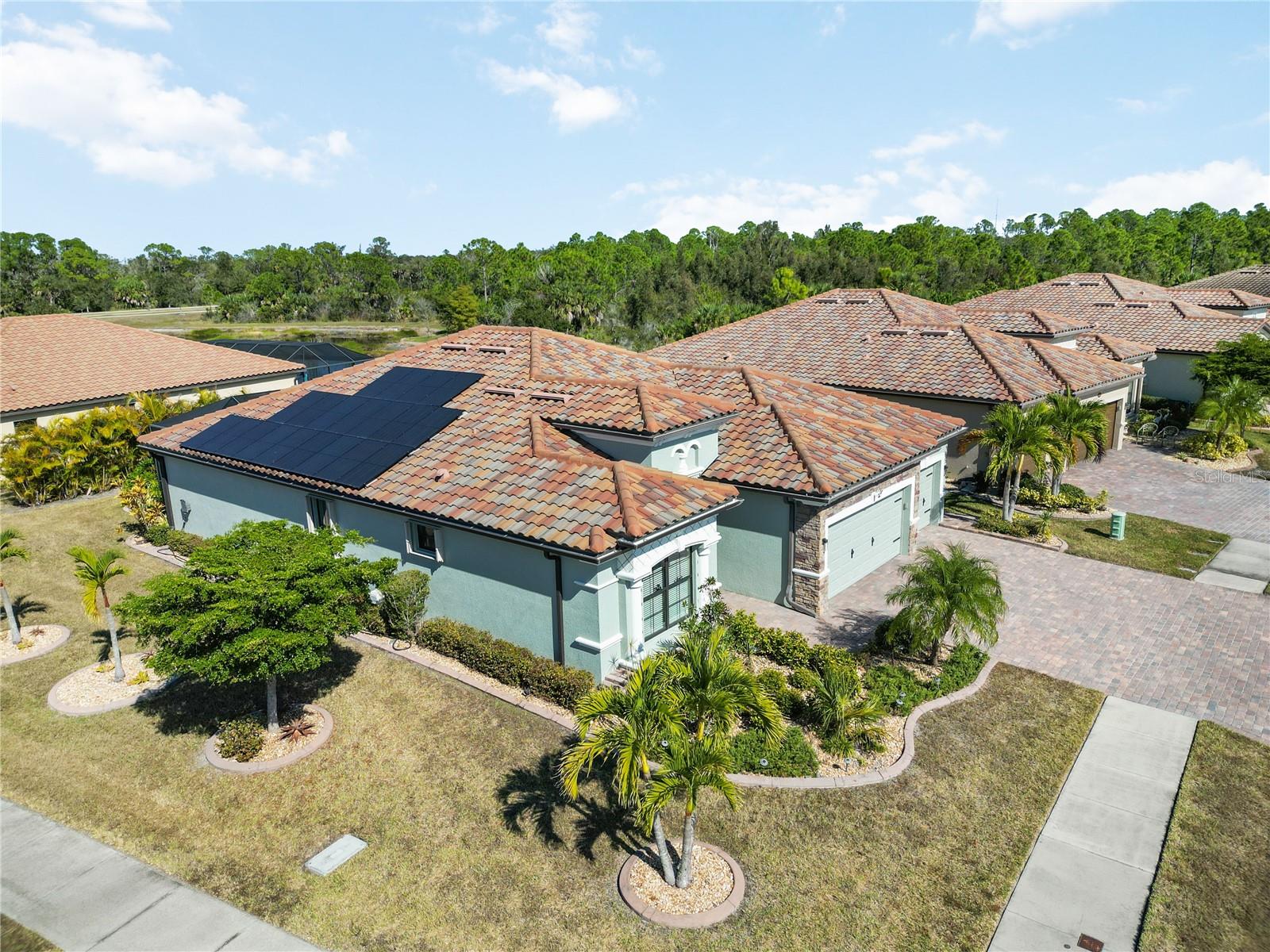 Welcome to this move-in-ready, tastefully upgraded Princeton II model, freshly painted inside and out in contemporary colors (2025). Situated on an oversized lot enhanced with mature palm trees and cactus landscaping, this 4-bedroom, 2-bath home offers 2,251 square feet of living space and a spacious 3-car garage.

The upgraded kitchen features LG stainless steel appliances, freshly painted cabinetry, custom pull-out shelving in the pantry and cabinets, a glass tile backsplash, and custom stonework on the island.

The dining area has been enhanced by removing the original pillar, creating a more open and modern layout than the standard Princeton II floor plan. A stylish glass chandelier completes the space.

The spacious living room showcases a dramatic floor-to-ceiling feature wall finished with imported Spanish tile, a 60-inch electric fireplace, an antique wood mantle, a ceiling fan, and an included 65-inch Samsung TV.

Throughout the bedrooms and den, you'll find luxury vinyl flooring installed in 2024, along with updated lighting and ceiling fans.

The 3-car garage is a standout feature with insulated doors and attic space, a mini-split A/C system, whole-house surge protection, overhead storage racks, a workbench, and a ceiling fan.

Outside, enjoy peace of mind and energy efficiency with Storm Smart accordion hurricane shutters, including a 28-foot electric Kevlar screen protecting the rear lanai. Additional exterior upgrades include full-house gutters, custom landscape curbing, a stainless steel salt/carbon water purification system, and 20 FULLY PAID OFF SOLAR PANELS GENERATING 8 KW OF POWER—PROVIDING SIGNIFICANT MONTHLY SAVINGS AND PROTECTION FROM FUTURE UTILITY RATE INCREASES.

The expansive 44' x 14' screened lanai features durable 20-gauge mesh screening and a Florida-built swim spa designed for year-round enjoyment.

Located in the resort-style community of Gran Paradiso, residents enjoy access to over 1,000 acres of lakes, ponds, and protected preserves, along with an elegant clubhouse, resort-style pool, fitness center, tennis courts, pickleball, basketball, walking trails, and beautifully maintained grounds. The community is just minutes from Gulf beaches, Atlanta Braves spring training, and downtown Wellen Park's shopping, dining, and entertainment.

The HOA includes lawn maintenance, internet, cable TV, access to all amenities, and gated community security.

Schedule your private showing today and experience the exceptional value, upgrades, and energy savings this home has to offer.