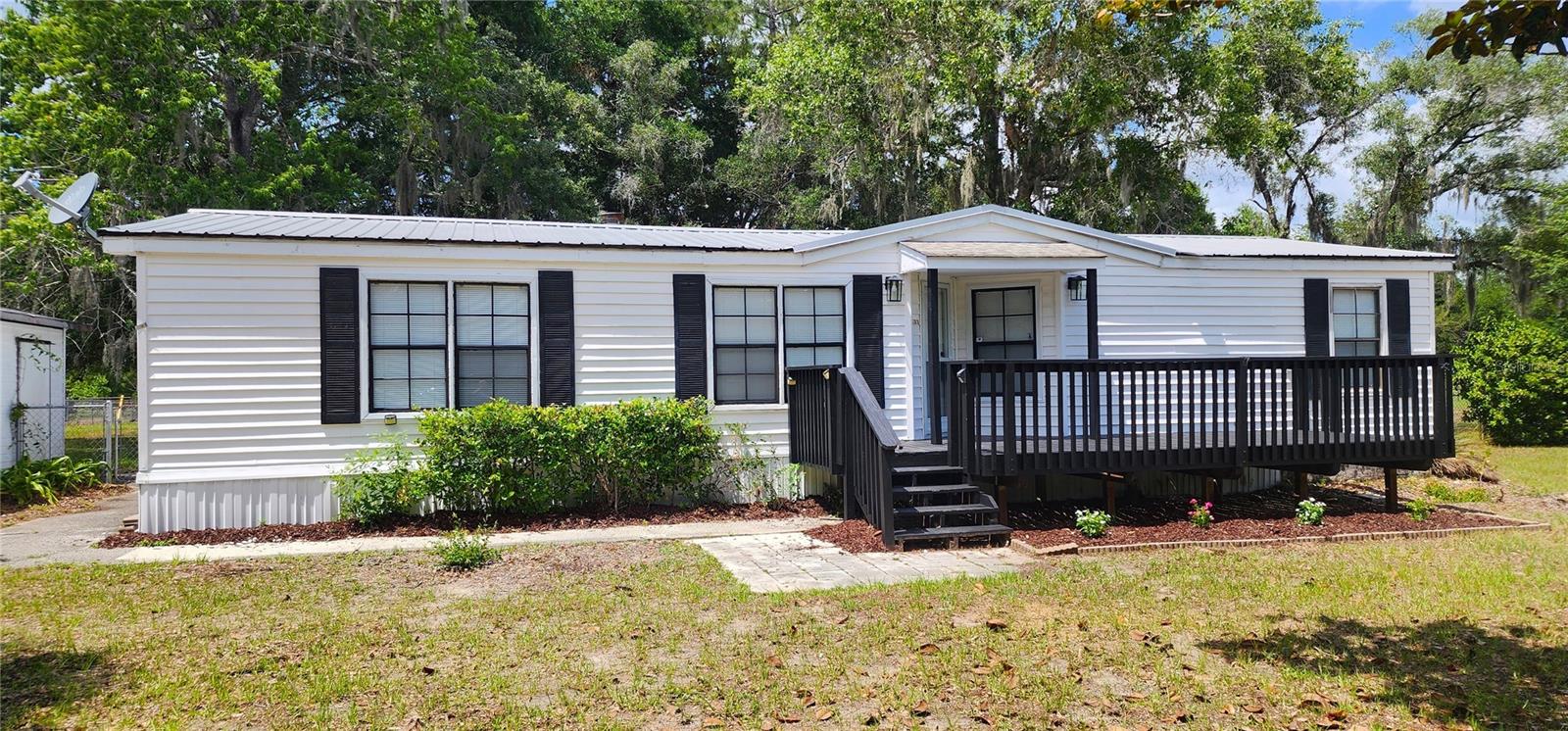 Charming and updated 3-bedroom, 2-bath mobile home built in 1987, situated on a beautiful 1-acre fully fenced lot. This move-in ready home offers numerous upgrades and features throughout, including a spacious living/family room with a real wood-burning fireplace, formal dining room, crown molding throughout, fresh interior paint, new luxury vinyl plank flooring, and all new light fixtures.

The remodeled kitchen features gorgeous granite countertops, brand-new cabinets, a new refrigerator, and an electric stove. Both bathrooms have been updated with new vanities, sinks, and toilets. Additional improvements include a new washer/dryer combo, central heat and air, and a new well bladder tank.

Outside, you'll find a durable metal roof, paved street access with concrete driveway, and a chain-link fenced yard complete with a gate across the driveway for added privacy and security. Enjoy relaxing on the freshly painted front deck or the fully enclosed and screened rear patio overlooking the backyard.

The property also includes a separate 20x30 workshop/garage with electric service, an outdoor storage shed, and a storm cellar with access door — offering plenty of storage, workspace, and peace of mind.

This property combines comfort, functionality, and country living with room to spread out while still being conveniently accessible.