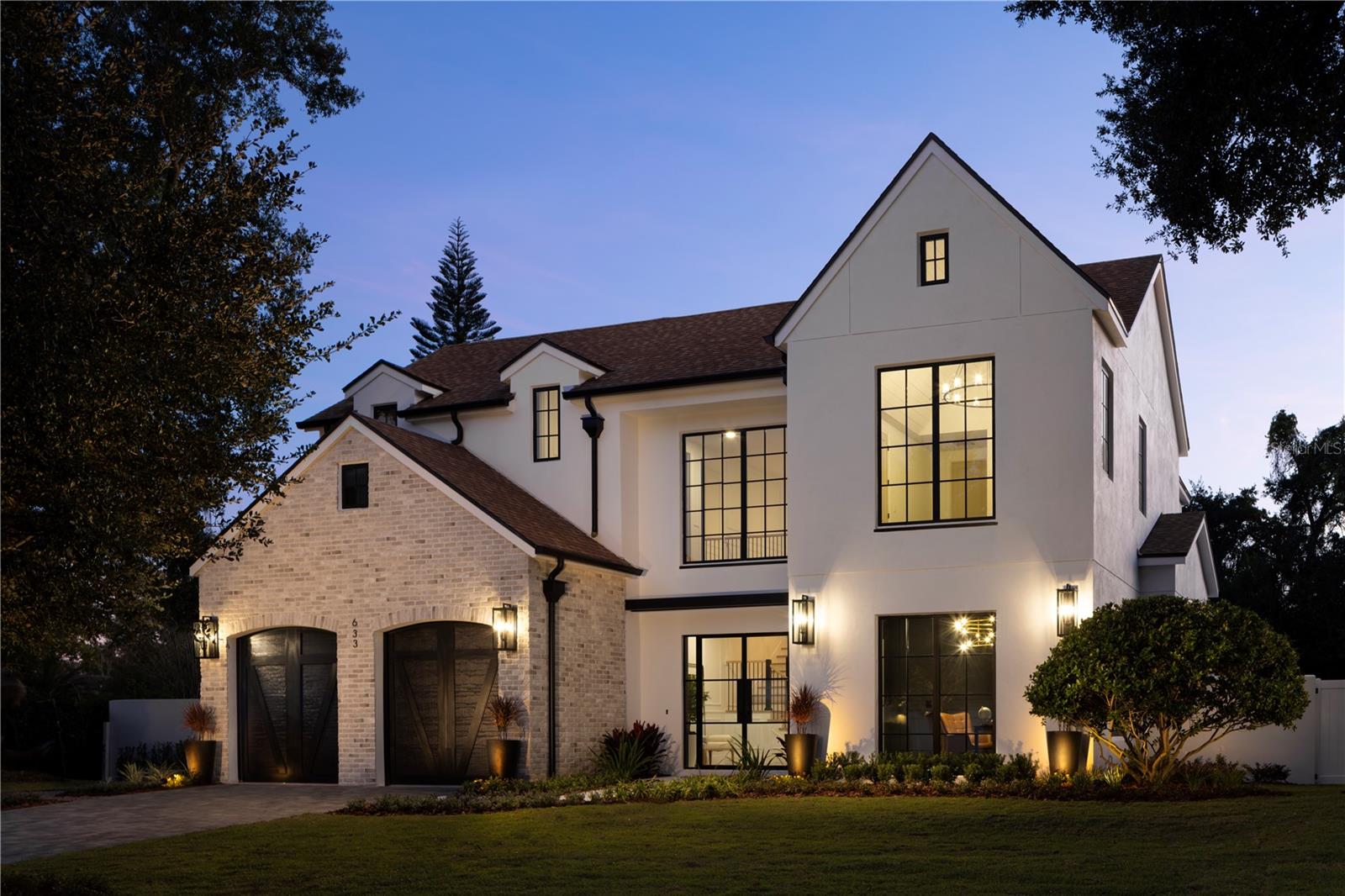 Stunning modern residence boasting almost 5,000 square feet, located in the heart of Winter Park. As you step through the glass front doors, you’re immediately greeted by the grandeur of the marble entry floors, setting the tone for the exceptional finishes throughout this beautiful home. From the gorgeous wood floors laid in a herring bone pattern, to the custom staircase, designer light fixtures, and beautiful mill work, no expense was spared in the construction of this exquisite residence. This luxurious home features two primary bedroom suites both with large walk-in closets and lavish bathrooms that would rival even the most prominent spas. The chef’s kitchen features exquisite custom cabinetry, porcelain countertops, a walk-in pantry, and top of the line appliances including a ILVE Nostalgie range, and a Dacor wine refrigerator for storing up to 100 bottles of your favorite wine. The bright open floor plan connects the family room, dining area, and outdoor spaces, making it a perfect home for entertaining. On the second floor you will find a total of 4 bedrooms, three bathrooms, a second laundry room, and a secret door that leads to a spiral staircase and a private roof top deck overlooking Lake Berry and views in the distance of downtown Orlando. Situated on a spacious lot, this property features a large, fenced yard with mature landscaping, perfect for outdoor activities and entertaining. The highlight of this home is the inviting pool, providing a refreshing oasis for those hot summer days. Jump on your golf cart and within minutes you’re transported to Park Ave, with its amazing shops, fine dining, and everything else that Winter Park has to offer. Schedule your private showing today and experience the epitome of luxury Winter Park living.
