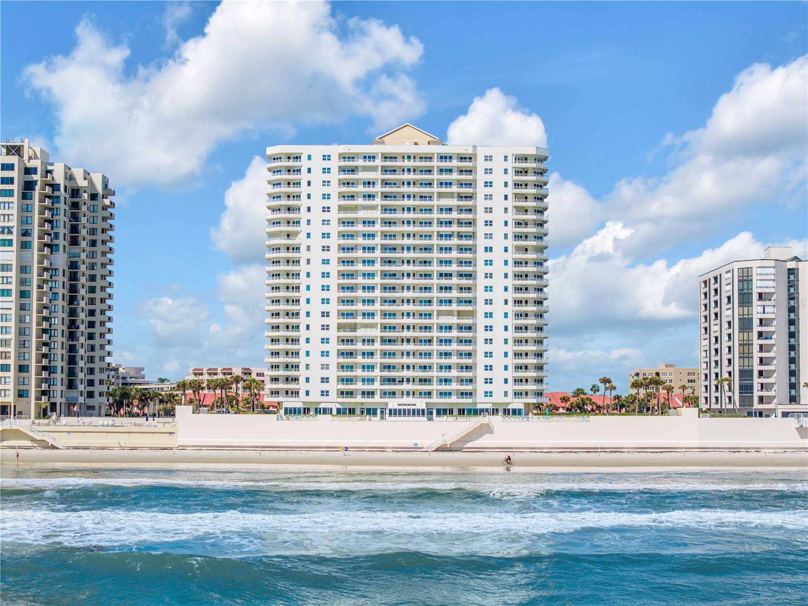 One or more photo(s) has been virtually staged. LOOK NO FURTHER, this is where your coastal dream truly begins. Whether you’re retiring, escaping for the season, or simply craving the rhythm of the ocean, this direct oceanfront residence invites you into a lifestyle that feels like a luxury cruise, only it never ends.

From the moment you step inside, the horizon takes center stage. Endless, unobstructed ocean views stretch as far as the eye can see, with rolling waves providing a constant, soothing backdrop. From your private balcony, mornings are nothing short of spectacular this time of year. Soft golden sunrises melt into the Atlantic, warm breezes drift in, and the sky becomes a canvas of color you’ll never tire of. And just when you think it can’t get better, you’ll have a front row seat to rocket launches, lighting up the night sky in a way that feels both thrilling and surreal.

This second floor unit offers a uniquely intimate connection to the shoreline, close enough to hear the waves crash and feel fully immersed, yet elevated to capture sweeping views over the pool and beyond to the vast ocean. Inside, the open and airy layout is designed to maximize both light and scenery, with a spacious kitchen and comfortable living areas that flow effortlessly together.

The lifestyle here is just as impressive as the view. Enjoy indoor and outdoor swimming, a fully equipped fitness center, sauna, hot tub, and inviting social spaces perfect for gathering with friends and neighbors. Step outside and you’re within easy walking distance to everyday conveniences such as grocery stores, dining, and banking, as well as nearby golf, tennis, and community activities.

With garage parking and every amenity thoughtfully provided, this is more than a home. It is your personal retreat, a place where every day feels like vacation, where the ocean is your constant companion, and where the salty air and sandy toes you’ve earned are finally yours to enjoy.