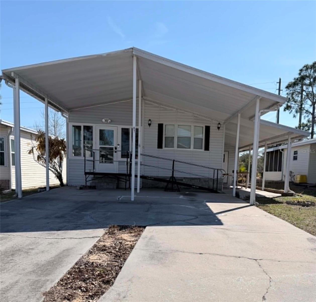 Beautiful, clean all-ages community conveniently located near Disney and many of Central Florida’s most popular attractions. Enjoy free boat and/or RV storage in the designated community area on a first-come, first-served basis. Community amenities include a private boat ramp with access to Lake Davenport, a dock, two pools, hot tub, and a well-maintained community center featuring a library, pool tables, exercise equipment, and an upstairs fellowship hall accessible by both elevator and stairs.

This charming 2-bedroom, 1-bath home features an enclosed front porch, updated kitchen with adjoining dining area, and a comfortable living room. The side storage area houses the washer and dryer (not included,) water heater, and water filtration system while still offering additional storage space. Relax outdoors on the covered side porch or enjoy the convenience of the covered 2-car carport.

A handicap-accessible ramp leads to the front entrance, providing easier access to the home. While the interior is not fully wheelchair designed, the ramp offers added convenience and accessibility.