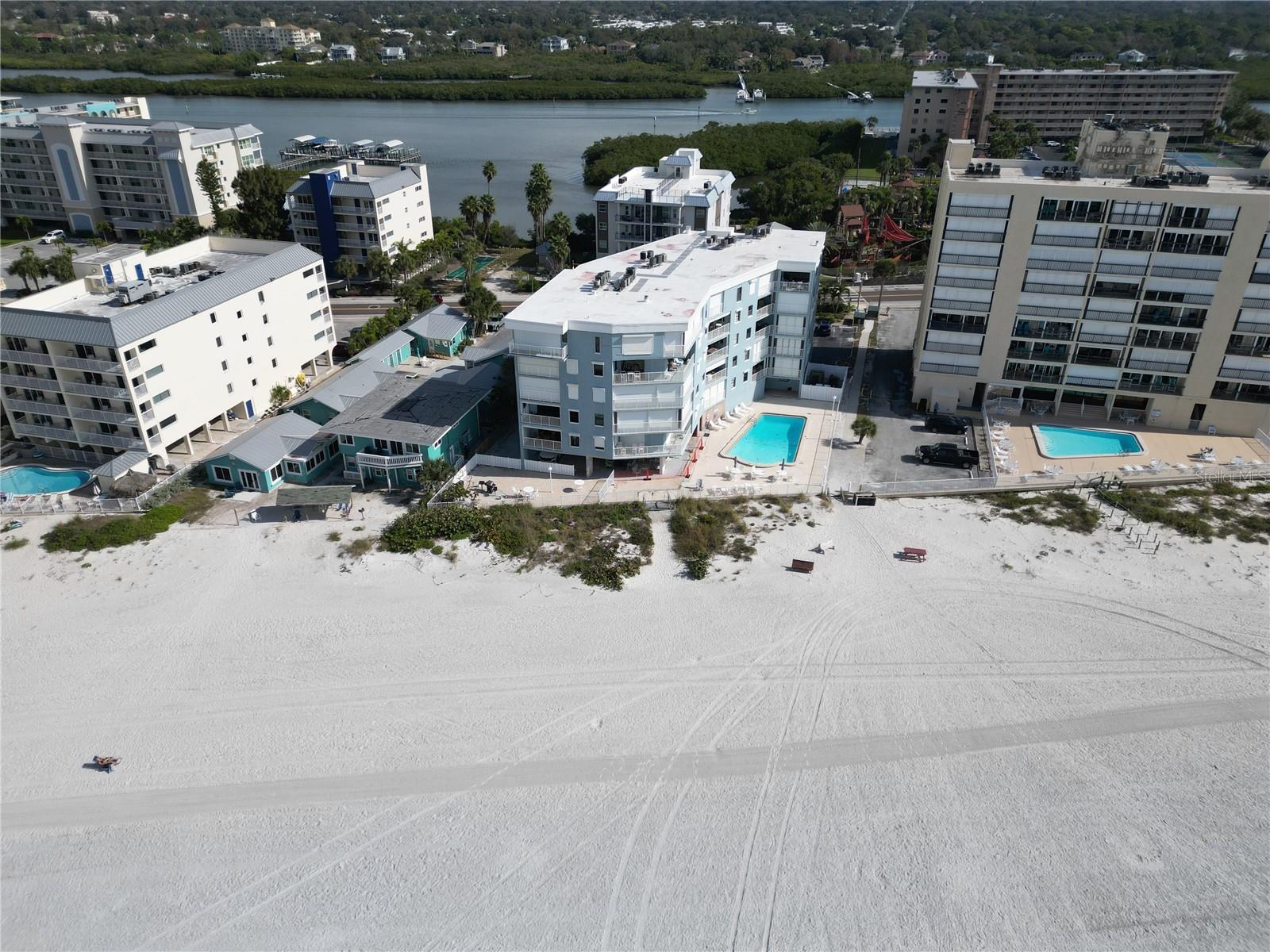 A rare opportunity to own a direct beachfront condo in the desirable Las Olas community! Welcome to 19500 Gulf Blvd, a beautifully maintained 2-bedroom, 2-bath residence offering breathtaking Gulf, beach, and pool views. This turnkey unit is being sold fully furnished, making it ideal as a primary residence, vacation home, or investment property. The open-concept floor plan is filled with natural light and showcases spectacular coastal views upon entry. The kitchen features updated cabinetry, granite countertops, dual stainless-steel sink, and two windows that enhance the bright and airy feel. Adjacent to the kitchen is a welcoming dining area, perfect for entertaining. The spacious living room opens to a generous beachfront balcony through sliding glass doors, creating a seamless indoor-outdoor living experience. Enjoy soothing Gulf breezes, gently lapping waves, and stunning sunset skies—an ideal setting for relaxing or hosting guests. The primary suite offers a private retreat with an en suite bathroom and a large walk-in closet. The well-sized guest bedroom also features a walk-in closet and private access to the guest bathroom, providing comfort and convenience for visitors. Additional features include an inside laundry room, balcony hurricane shutters, and updated windows throughout. The Las Olas community is well maintained and offers a beachfront pool with expansive sun deck and umbrellas, direct beach access, clubhouse with full kitchen, and a BBQ area. Enjoy a prime location within walking distance to restaurants, bars, coffee shops, shopping, and putt-putt golf. This unit includes an assigned parking space, along with ample guest parking. Tampa International Airport and St. Pete–Clearwater International Airport are both under an hour away, making travel effortless. This exceptional beachfront condo is truly move-in ready. Don’t miss your opportunity to own a piece of Gulf-front paradise!