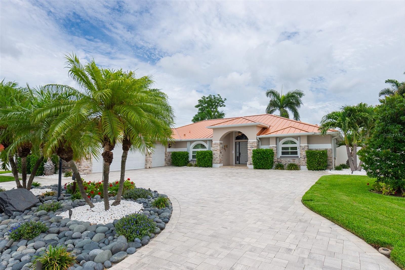 Soak up the pinnacle of living in comfort and style! 2002 CUSTOM-BUILT by premier local developer “Cottle & Watkins,” situated in one of Seminole's most desirable locations along cul-de-sac, 40+ feet ABOVE SEA LEVEL, this property delivers EXCEPTIONAL CURB APPEAL ($300,000+ Upgrade in 2022) with elegantly paved circular driveway around lit & landscaped yard rocks, a stunning & unique copper-colored METAL ROOF (2021), all newer windows, and a majestic beveled glass front entry door with side panels ($8,000). Step inside to 9ft ceilings, a welcoming foyer opens to an impressive GREAT ROOM with newer kitchen, Granite counters and backsplash, upgraded appliances (Jenn-Air oven), pull-out drawers and large breakfast bar, that flow seamlessly into the main living- and dining area, designed for every day living and effortless entertaining. The primary suite provides a peaceful private retreat with en-suite bath equipped with high-end, luxurious “Toto” Washlet toilet & Bidet, JACUZZI TUB and separate WALK-IN SHOWER, plus “Grohe” faucets and handles, while two additional bedrooms give space for family, guests, or a dedicated home office. Other upgrades and features include: Corian & Granite counters, hardwood- & wood-laminate flooring, gas fireplace, central vacuum system, tank-less water heater, garbage compactor, spacious laundry room (new "Speed Queen" - commercial heavy duty washer & "Whirlpool" front load dryer), “Daikan” A/C (2026), water softener, custom interior shutters & adjustable blinds, retractable sliding doors, crown moldings, Generator (sold as-is), large HEATED FREE-FORM inground POOL, sprinkler system on reclaimed water, white vinyl fencing with gates. Step outside to your private SCREENED POOL OASIS, with electric pool heater, making year-round enjoyment effortless. The attached 3-Car garages are a stand-out feature with epoxy-coated floors, built-in storage, hurricane-rated doors, additional refrigerator, offering versatile space for work shop, boat storage or additional vehicle collection. Existing SURVEY provided; Owner has TERMITE BOND. This move-in ready coastal gem combines luxury with convenience and offers easy access to Seminole City Center, Seminole Recreation Center, St. Pete College, dining, shops, parks, medical offices, top-rated schools, award-winning Gulf beaches and only 30 minute drive to Tampa International Airport. Schedule your showing today and experience all that this home has to offer – Hurry, won't last!