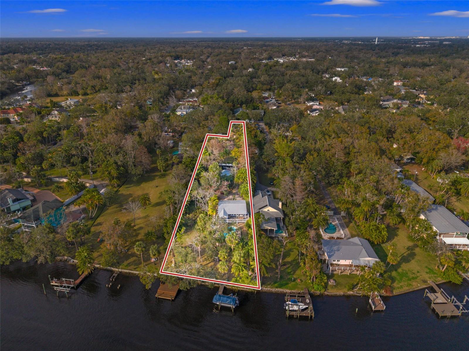 Welcome to 906 W Henry Avenue, a rare opportunity to own prime riverfront real estate in one of Tampa’s most desirable and rapidly growing neighborhoods, Seminole Heights. This is your chance to own a property that feels more like a private park or nature sanctuary than a typical homesite, and build the custom waterfront estate you've always envisioned. The best part? Much of the heavy lifting has already been done. The property features existing infrastructure, including a detached garage, swimming pool, private docks, boat lift, and an existing home that allows you to live on-site while designing and permitting your dream residence. Situated directly on the Hillsborough River with over 100 feet of waterfront frontage, this exceptional property offers endless possibilities for homeowners, builders, investors, and waterfront enthusiasts alike. While the existing home provides immediate usability, the true value lies in the remarkable homesite itself. Whether you choose to renovate and enjoy the current residence, create a private waterfront retreat, or build a one-of-a-kind custom estate, opportunities like this are becoming increasingly rare. Enjoy breathtaking river views, stunning sunsets, and direct access to the water from your own backyard. Two private docks provide the ideal setup for boating, fishing, kayaking, paddleboarding, or simply embracing Tampa’s sought-after waterfront lifestyle. With no HOA restrictions and ample room to create a luxury custom residence, the possibilities are limited only by your imagination. A large gorgeous shared driveway that leads back to your private, serene piece of nature. Located just minutes from Downtown Tampa, Armature Works, the Tampa Riverwalk, major hospitals, dining, shopping, and entertainment, this property offers the perfect balance of peaceful waterfront living and convenient urban access. Whether you're searching for a unique riverfront residence, an extraordinary luxury homesite, or a long-term investment in one of Tampa’s most coveted waterfront corridors, 906 W Henry Avenue presents a truly rare opportunity to secure your piece of the Hillsborough River.