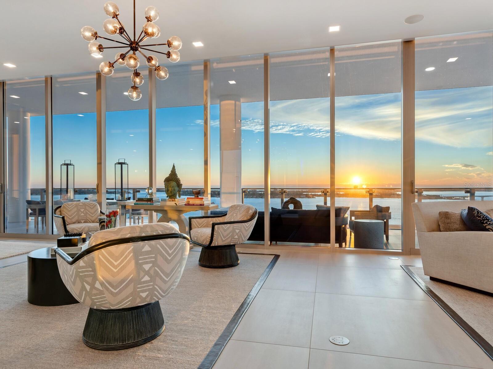 The pinnacle of ultra-luxury living in one of the highest waterfront residences on the Gulf Coast, EPOCH 17 is a full-floor masterpiece of architecture and design with spectacular vistas extending over Sarasota Bay to the Gulf of Mexico and in every direction across the city skyline. Sprawling over 5855 square feet with a magnificent owners’ wing and three luxurious en suite guest suites, this residence integrates exceptional comfort, cutting-edge technology, and haute design elements in every feature for an unequivocally lavish lifestyle. Beyond the impressive appointments of the interior, floor-to-ceiling impact glass walls and three enormous private terraces showcase 360-degree views and modern elegance of this chic new construction building. 
With private elevator access, a spacious foyer leads to the great room that spans the width of the building to showcase stunning, unobstructed sky-high views through a full wall of floor-to-ceiling glass that opens seamlessly to the immense wraparound terrace. Soaring 12’ ceilings and an open floor plan add to the grand scale of the central living spaces, with distinctive zones arranged to preserve a sense of intimacy. Adjacent to the great room and ideal for large-scale entertaining, the open dining area enjoys direct access to the terrace and additional seating both outdoors and at the oversized dual-height kitchen island. The gourmet kitchen extends to a separate butler's pantry and features bespoke Italian cabinetry by Cucine Ricci, a 3’ Galley sink, expansive storage, quartzite and Caesarstone surfaces, and highest-end Gaggenau appliances that include six-burner gas range, double wall ovens, side-by-side refrigerator and freezer, and wine refrigerator and ice maker in the dedicated bar area. 
With spectacular west-facing vistas, the owners’ suite is a luxury retreat beyond par. The massive bedroom encompasses a separate seating area and direct access to the bayfront terrace with additional private lounge space. Beyond the sleeping area, an enormous dressing room and additional walk-in closet are indulgent companions to the oversized bathroom with a huge walk-in shower, soaker tub, double vanities with seating, and separate water closet. 
Decorative elements include Phillip Jeffries wall coverings, exquisite lacquering, Robern vanity installations, custom California Closets systems, and more. Premium technological integrations include Lutron automated shades, lighting control, and temperature control; A/V technology, sound system with built-in speakers in every room and bathroom; built-in WiFi and repeater system; multi-zone air conditioning; whole home water purification and reverse osmosis system for the kitchen. Two separate in-home laundry facilities, a dedicated guest beverage station, multiple storage rooms, and a private enclosed 3-car garage enhance the conveniences. 
EPOCH was conceived to accommodate the highest level of luxury living, designed with meticulous detail and striking features that celebrate the renowned mid-century modern style of the Sarasota School of Architecture. The 23 exclusive residences enjoy world-class amenities, personalized services, and enhanced security. Desirably located on the shoreline of Sarasota Bay and within steps of the city’s cosmopolitan core, EPOCH marries contemporary elegance and unrivaled quality for the height of luxury living on the Gulf Coast. Bedroom Closet Type: Walk-in Closet (Primary Bedroom).