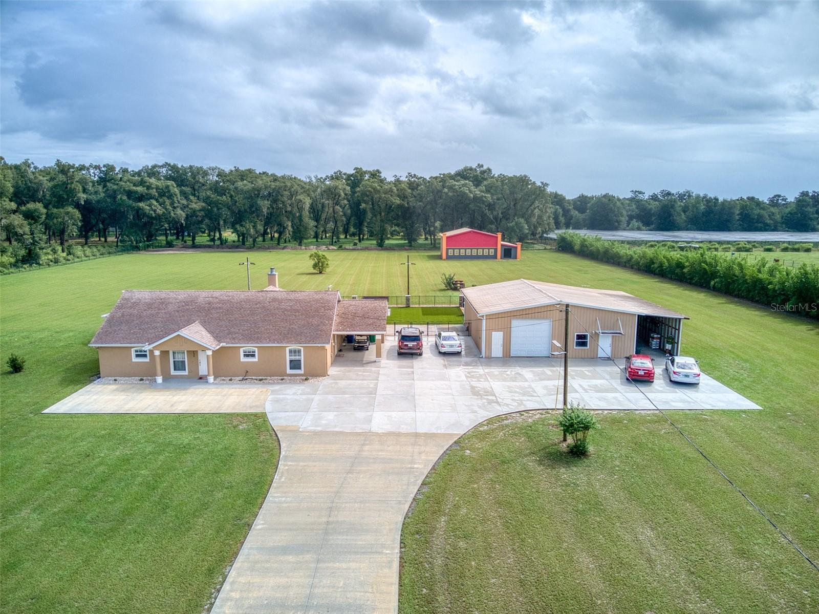 HUGE PRICE REDUCTION !!!  Exceptional Pierson Property on 5 Acres - No HOA, No Flood Zone, No CDDs. Welcome to this remarkable Pierson, FL property, offering an unparalleled blend of space, luxury, and freedom. This estate boasts the rare trifecta of NO HOA, NO FLOOD ZONE, and NO CDDs, giving you the ultimate in flexibility and lifestyle choices. As you enter the property, you'll be captivated by the inviting saltwater pool, surrounded by a meticulously crafted stamped concrete deck and enclosed by a sturdy metal fence. The surrounding synthetic grass requires minimal upkeep, ensuring you have more time to relax and soak up the Florida sun. An exquisite outdoor kitchen, complete with a grill and sink, sets the stage for delightful al fresco dining and entertaining. The entire property is enveloped by a chain-link fence, fortified by solid concrete block columns up front and a substantial metal gate, representing an investment of $75,000. A thoughtfully designed concrete driveway, valued at $25,000, leads you to the primary residence. Inside the main house, you'll find 1,874 square feet of living space featuring a well-thought-out split floorplan with the master suite separate from the other bedrooms. Vaulted ceilings create an expansive and open atmosphere, while a wood-burning fireplace adds warmth and character. LED lighting, updated ceiling fans, and modern light fixtures enhance the overall appeal of this welcoming home. The updated kitchen is adorned with stainless steel appliances and elegant countertops, complemented by laminate wood flooring in the primary living areas. French doors seamlessly connect the interior to the covered patio, extending your living space into the great outdoors. Adjacent to the main house, a substantial metal building houses a 2-car garage, a guest apartment offering 855 heated square feet (comprising a living-dining room combo and a separate bedroom with a private bathroom), and an open 517-square-foot area ideal for an RV, boat, or other recreational equipment. Further enhancing the property's versatility is a steel building spanning 2,000 heated square feet, complete with a brand-new 5-ton A/C unit, and a camper or boat port boasting an expansive 710 square feet of open space. The estate comes fully equipped with a 28,000 peak-watt generator, a golf cart, a riding lawn mower, a garage freezer, and gym equipment. All appliances, including the washer and dryer, are included for your convenience. The water heater was replaced in 2020, and the A/C unit in the main house is from 2018. The property is served by public water and features septic tanks. One of the intriguing features of this property is the partially completed conversion of the metal building at the rear, initially intended to become a fully functional movie theater. Alternatively, this space can be transformed back into a barn by installing the three garage doors, which are thoughtfully stored on-site. Enjoy the prime location of this estate, with easy access to some of Florida's finest cities, beaches, springs, lakes, forests, and preserves. Whether you seek a peaceful retreat or a venue to host family and friends by the pool or in the guest house, this estate provides ample storage for all your recreational toys, RVs, boats, 4-wheelers, and campers. With the added security of 5 fully fenced acres of land, your dream lifestyle awaits. YOUTUBE: https://youtu.be/HbqiX4eHPxE