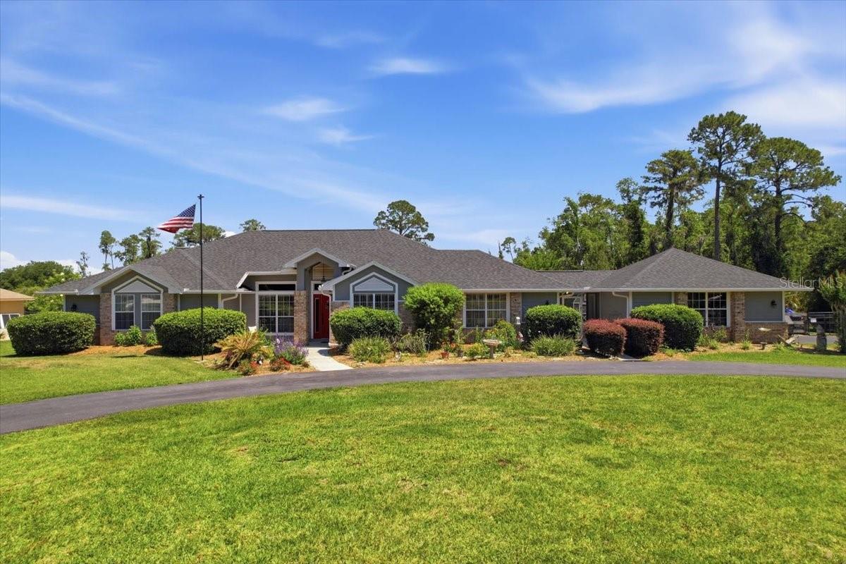 Set on a full acre in a quiet, well-kept community where every lot is at least an acre, this one offers the kind of room and quiet that's getting harder to find this close to town. The option to purchase the adjacent one-acre lot (Parcel ID: 03-20-26-0100-000-04900) creates a rare opportunity to double your acreage into an exceptional two-acre private estate! NEW ROOF 2025. There's a whole home water treatment system, irrigation in front yard, a barn-style shed, and a screened breezeway that connects the home to the garage so you're never caught in the rain hauling groceries or heading out to the car in the morning. Inside, the layout opens up around a stone fireplace and a kitchen built for people who actually cook: granite counters, an island with seating, a wall of cabinets, and a pantry that earns its keep. Vaulted ceilings keep the main living space feeling tall and bright, and wood floors run throughout the home. The primary suite has its own slider to the back, a soaking tub, separate vanities, and a walk-in closet that actually fits a wardrobe. Additional bedrooms are spread thoughtfully so guests, kids, or a home office aren't tripping over each other. A large walk-in storage closet positions itself at the end of the hall, ensuring you can save the garage for housing cars or your golf cart (Tavares is one of the most golf cart-friendly cities in Florida!) Out back, a generous screened porch with three sets of sliders and ceiling fans wraps along the rear of the home. It's the kind of space where mornings start with coffee and evenings stretch long. Beyond it: open lawn, mature oaks, and a fully fenced yard with room to breathe. Down the street, the community clubhouse is a destination in itself, a stone barn with a working water wheel out front, a comfortable lounge upstairs, and a game room with ping pong and more. The kind of shared amenity that actually gets used. Then there's the location, which is the quiet flex. Tavares, America's Seaplane City, is just minutes away, with Wooton Park on Lake Dora, the seaplane base, and a downtown lined with waterfront restaurants where you can watch planes land while you eat. Mount Dora is fifteen minutes the other direction: a historic downtown with no chain restaurants allowed, more than twenty independent spots packed into a three-block stretch, antique shops, art galleries, the Lakeside Inn, and Renninger's antique center on the edge of town. Lakeshore Drive connects the two through six miles of oak-canopied lake views, a road locals bike on weekends. Combined with Eustis, these three towns form Lake County's "Golden Triangle," the heart of an area that built its identity around water, antiques, and small-town downtowns that still feel like small-town downtowns.