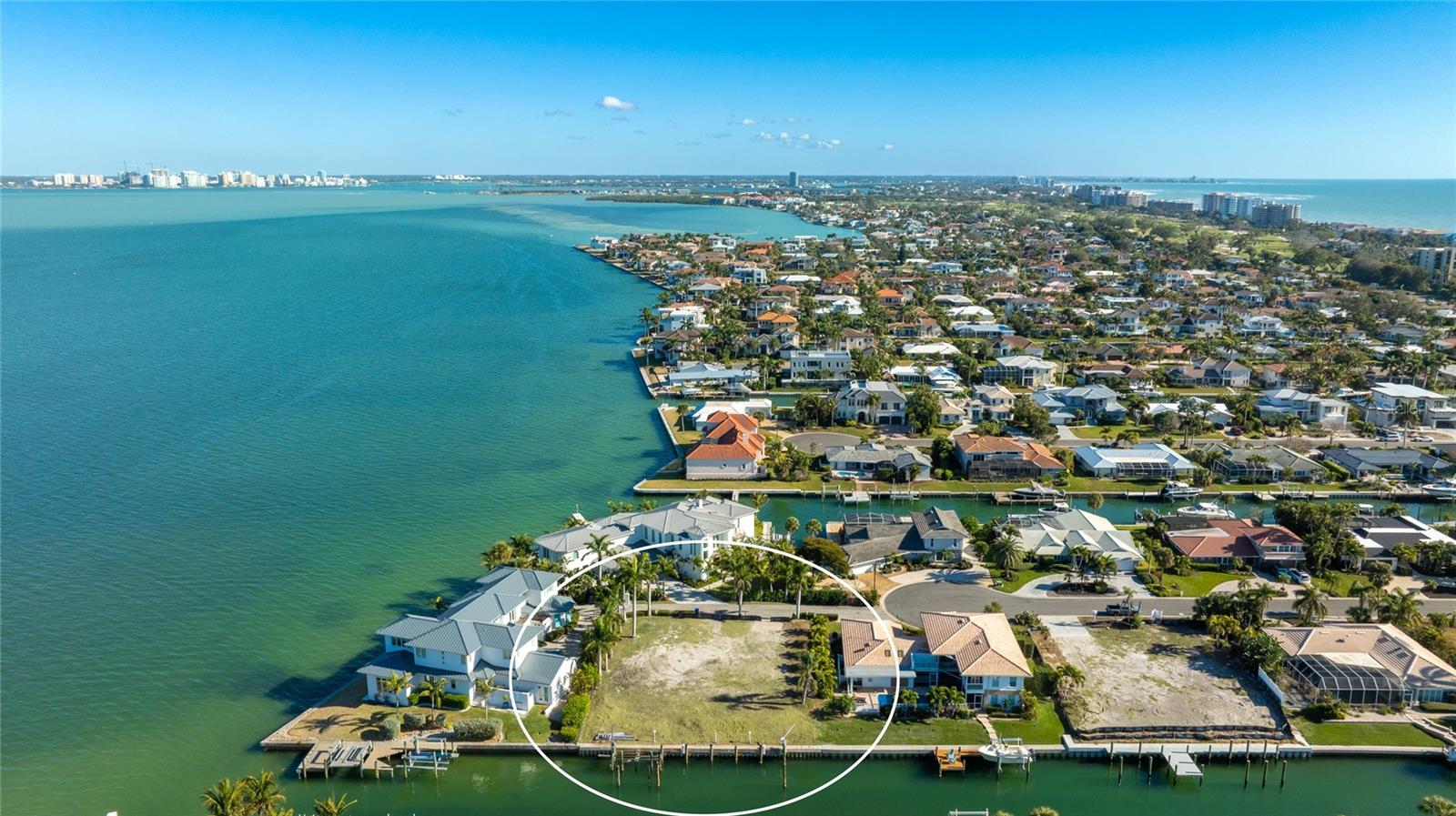 Imagine designing a home where mornings begin along the water, afternoons are spent boating, and evenings end on your rooftop deck, taking in the Sarasota skyline and glowing sunsets over the Gulf of Mexico. This exceptional canal-front lot in Country Club Shores offers the opportunity to create exactly that lifestyle on Longboat Key. One of the largest canal-front lots in the neighborhood, approximately 1/3 acre, the property can accommodate a custom home of up to approximately 5,000 square feet and is located just one lot from Sarasota Bay, providing the perfect balance of canal frontage and immediate access to open waters with no bridges. A newer seawall and private dock are already in place—so whether it’s a quick sunset cruise, paddleboarding in the morning, or weekends on the bay, the waterfront lifestyle is effortless and ready to enjoy. The community features private, deeded beach access, offering the rare ability to enjoy both bay and Gulf lifestyles from one location. Custom home plans designed by award-winning DSDG architect Mark Sultana are available and can be built by Brista Homes, a prominent builder in Country Club Shores, offering a streamlined path forward in bringing your dream home to life. Buyers may also choose to work with Brista Homes to bring their personalized vision to life or work with their own architect and/or builder, if preferred. Perfectly positioned minutes from the Longboat Key Club with membership opportunities, private beach access, the boutiques and dining of St. Armands Circle, and the cultural energy of Downtown Sarasota, this location offers a rare blend of convenience and coastal sophistication. This is more than a vacant lot—it’s an invitation to build a life centered around the water, the sun, and everything that makes Longboat Key one of Florida’s most desirable coastal destinations.