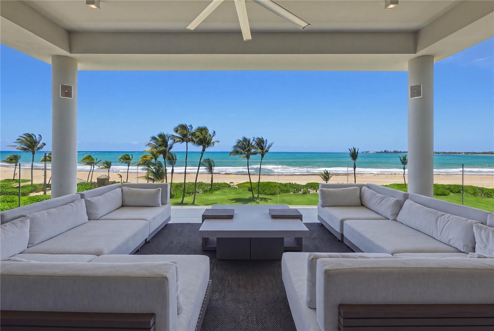 Situated directly along the pristine coastline of Bahia Beach, Ocean Drive 3301 offers an extraordinary beachfront retreat within the exclusive gated enclave of the Four Seasons Resort and Residences in Rio Grande. Spanning 4,424 Sq. Ft. of indoor and outdoor living, this turnkey home seamlessly blends contemporary architectural refinement with panoramic views of the Atlantic Ocean. The main living and dining area with wet bar is framed by floor-to-ceiling glass walls that bathe the residence with natural light and create an effortless indoor-outdoor flow. Exquisitely curated for the culinary enthusiast, the chef-grade kitchen features an oversized waterfall island with an integrated cooktop and custom cabinetry, as well as Sub-Zero and Wolf appliances. Designed with a harmonious layout, the home offers three spacious ensuite bedrooms with walk-in closets, powder room and dedicated laundry room. The primary oceanview suite is highlighted by a spa-inspired bath with freestanding soaking tub, rain shower and dual marble vanity. Extending the living space outdoors, the expansive covered terrace is accented by a complete summer kitchen with BBQ, wet bar, and dining area overlooking the beach and lush coastal greenery. Bespoke finishes throughout include polished marble and porcelain tile flooring, 10’2’’ ceilings, recessed lighting, smart-home integration and direct elevator access. Set across more than 483 acres of preserved natural landscape by the ocean, Four Seasons Resort and Residences is a Five-Star, Five-Diamond Resort and only Certified Gold Audubon Signature Sanctuary in the entire Caribbean. Residents enjoy exclusive access to world-class amenities such as two miles of secluded beach, the Robert Trent Jones Jr. championship golf course, the Four Seasons Spa and Wellness Center, beach club, a variety of pools, fine dining restaurants, tennis courts, state-of-the-art fitness center, nature trails, water sports and nearby marina. Combining rare privacy, natural beauty and unparalleled service, Bahia Beach sets a new standard for Caribbean resort living.