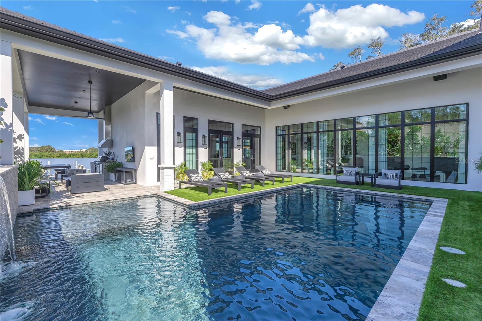 Timeless sophistication and pure luxury define this SINGLE-STORY one-of-a-kind custom waterfront home in St Petersburg.  Designed to be a forever home, you will marvel at the fine craftsmanship and elevated finishes throughout.  A vaulted ceiling open-air living room greets you to this three-bedroom, three-bathroom, and 2 half-bathroom home.  Constructed to the latest codes, this all-block construction home with a tile roof and whole-house natural gas generator stands resilient to Florida weather remaining unscathed from the recent storms (no flooding in home, garages, or pool).  Enjoy expansive and unobstructed waterfront views from the open-concept kitchen and living room adorned with custom glass windows and doors to allow an abundance of natural light.  The pool is extremely private and leads to an outdoor kitchen and back patio overlooking Coffee Pot Bayou.  Lastly, the dock with a 10,000 pound boat lift is extremely durable and constructed with DECKWEAR that is cool to the touch even on the hottest days. Just minutes to the Vinoy Golf Course, the Coffee Pot Bridge, and downtown St Petersburg the ultimate lifestyle is right there for you to enjoy.