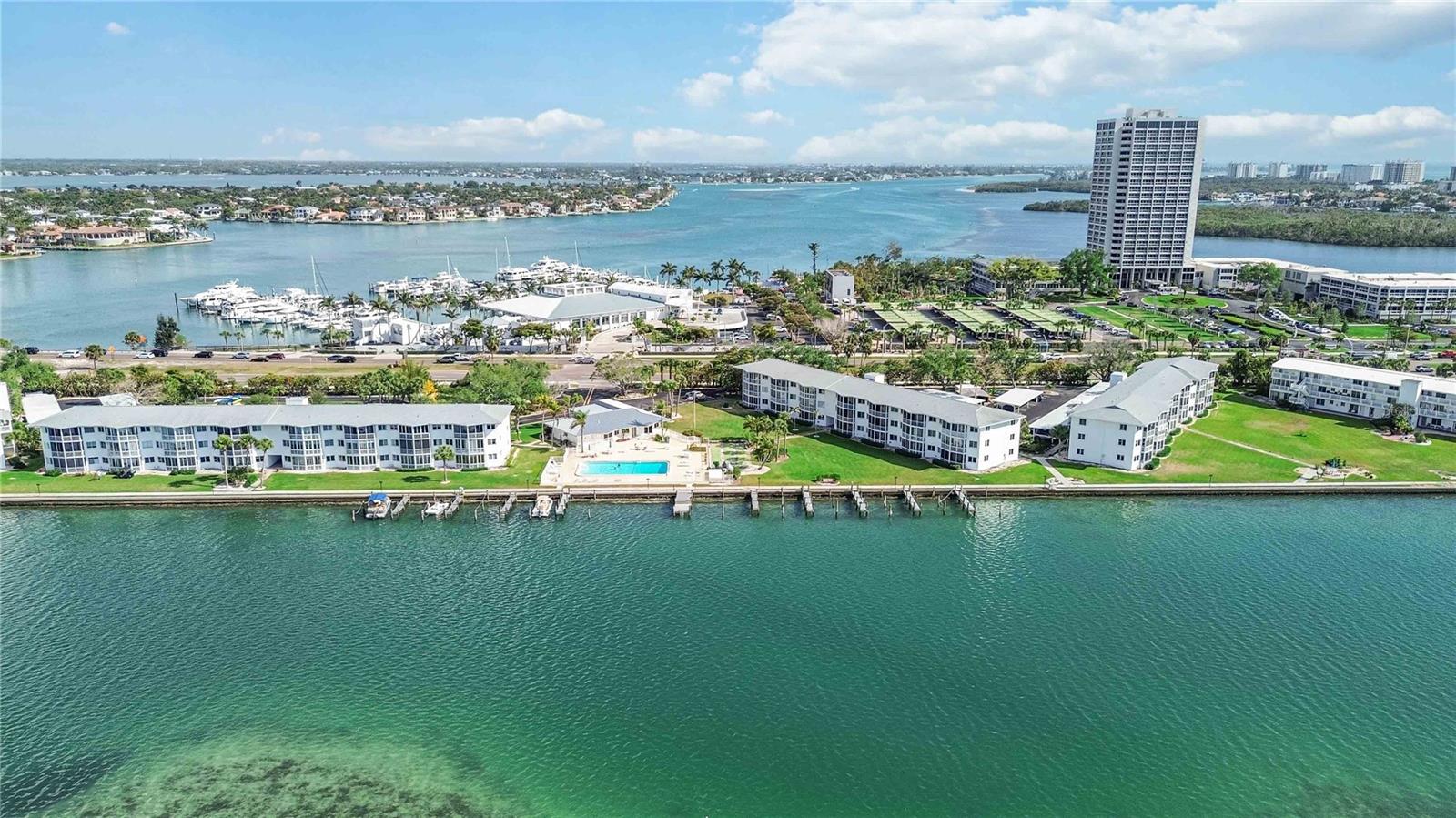 Virtually Staged. Sarasota Bay is your backyard in this stunningly remodeled, first-floor waterfront sanctuary located in the premier 55+ community of Sarasota Harbor East. This residence offers a front-row seat to nature’s theater with direct views of dolphins, manatees, and vibrant sunsets from your private lanai. The heart of the home is a brand-new kitchen featuring sleek quartz countertops, contemporary cabinetry, a stylish backsplash, a Bosch oven and premium induction cooktop, and new stainless appliances (refrigerator and dishwasher). Peace of mind is built-in with a 3-year-old AC unit, new water heater, and updated plumbing. Perfectly positioned between St. Armands Circle, Lido Key, and downtown Sarasota, the community offers an unparalleled lifestyle: enjoy a bayfront pool, a clubhouse with private changing facilities, and secured bike and kayak storage. A boater’s dream, the community provides boat slips (up to 30 ft) at no additional cost to residents—a rare and valuable find. The comprehensive HOA fee ensures a maintenance-free lifestyle, covering exterior grounds, building maintenance, cable, internet, water, sewer, and trash. Complete with covered parking, dedicated storage, and laundry facilities, this is turn-key coastal luxury at its finest.