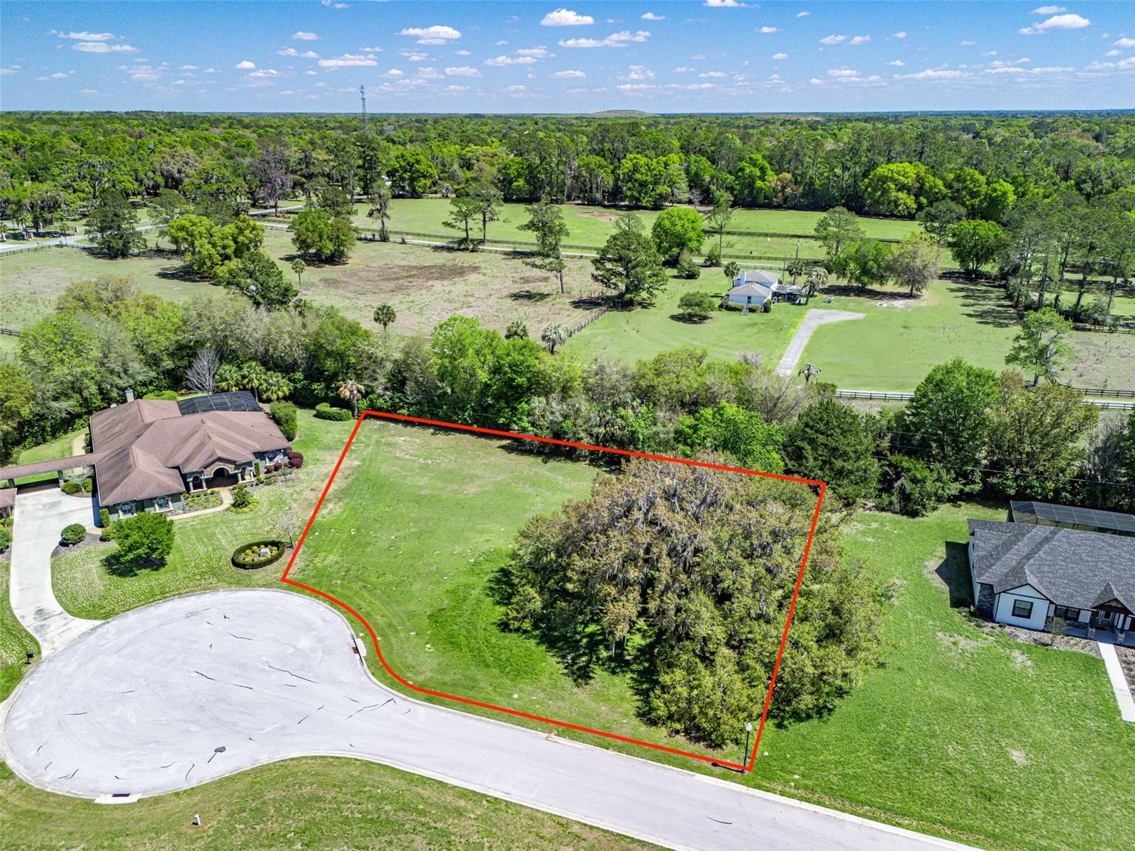 Bring your dream home to life in the gated community of Legendary Trails in Southeast Ocala! Situated on a cut-de-sac street with a buffer of trees along the rear property line, a community water retention area across the street, and a stunning mature oak on the South side of the property. Legendary Trails is a deed-restricted, custom home community with architectural guidelines and a minimum living square footage of 2,700, helping preserve consistency and long-term value throughout the neighborhood. Located in sought after Southeast Ocala, less than 1 mile to the Santos Trailhead and under 2 miles to The Country Club of Ocala, plus convenient access to Belleview and The Villages to the South.