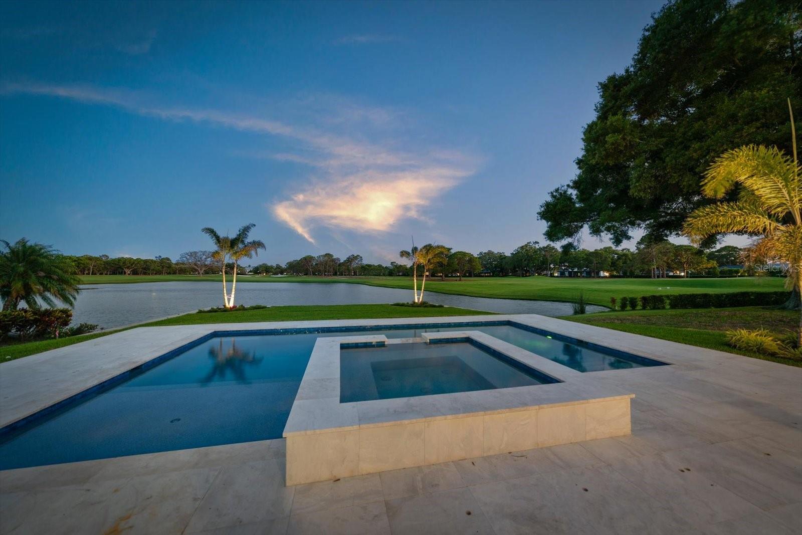 Virtually Staged. ONE-OF-A-KIND WATERFRONT ESTATE ON PELICAN GOLF COURSE. Set on a unique, private half-acre cul-de-sac lot overlooking the water and the fairways of the Pelican, this 4 to 5 bedroom, 4 bath residence with a private in-law suite has been completely reimagined into a bold, design-forward showpiece. No detail has been overlooked in this luxury, custom home. The commanding hand-laid stone exterior opens to interiors featuring 10 to 13 foot ceilings with crown molding, luxury hardwood flooring, dramatic designer lighting, and a custom wine bar. New impact windows and sliders flood the home with natural light while capturing spectacular water and golf course views. The stunning chef’s kitchen is a true centerpiece, showcasing illuminated Cristallo quartzite countertops, custom cabinetry, and premium Thermador appliances—perfectly suited for both everyday living and elevated entertaining. The primary suite is a warm and inviting retreat with picturesque course views and a custom gas fireplace. The spa-inspired bath features dual vanities with lighted mirrors, a makeup area, and expansive his-and-hers walk-in closets. The main home offers three additional spacious bedrooms and two beautifully designed baths with luxury finishes. A thoughtfully designed casita features a private entrance, a full custom kitchen, and a beautifully appointed bath with a whirlpool tub and separate shower—ideal for multigenerational living, a guest suite, an office, or whatever you can imagine for this incredible flex space. 
Step outside to resort-style living with a custom heated saltwater pool and spa, set against tranquil water and golf course vistas. Marble pavers span the entire pool deck and covered lanai, creating a seamless space for relaxation and entertaining. Other new features include a standing seam metal roof, dual Trane HVAC systems with all new ductwork, Icynene insulation, dual natural gas tankless water heaters, and a whole-house water treatment system. Nearly 1,100 sq. ft. air-conditioned, finished garage with high ceilings provides year-round comfortable parking and storage. Ample outdoor parking, mature landscaping with custom lighting, a deep well, and a whole house generator complete this one-of-a-kind home. Located just minutes from Clearwater Beach, fine dining, boutique shopping, and premier clubs, including Pelican Golf Club and Belleair Country Club, this exceptional, redesigned residence offers a rare opportunity to enjoy luxury living in one of Florida’s most sought-after coastal golf communities. One or more of these photos are virtually stage.