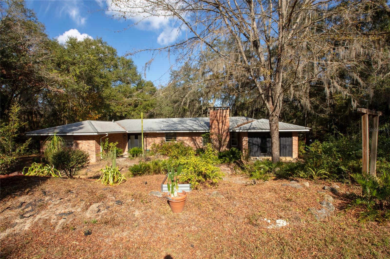 Welcome to this touch of paradise hidden from the road. Approximately 600 ft from the road, this spacious 3 bedroom/ 2 bath brick home is situated on two parcels totaling 4.47 acres. Wood burning fireplace with built in benches on each side. Garage has been converted into a master bedroom with 2 built in closets, a bathroom, and a laundry room. Large kitchen with farmhouse sink, lots of counter space, soft close cabinets, and a pantry. All appliances stay. Lots of storage throughout the home. Built in Ikea shelves in family room. Enjoy your coffee while sitting out on the back deck overlooking the back yard. Chicken coop in backyard. Well bladder tank replaced within the last 10 yrs. Metal roof 1995 and HVAC installed 2002. Ceiling and interior walls recently painted. Shipping container used for storage. Green shed has electric. 300' frontage of Lake Serena. Two entrances on property. Country living at it's best! Additional Parcel ID: 10-09-23-0000-0282-0000/732 SR26 - 1.84 acres