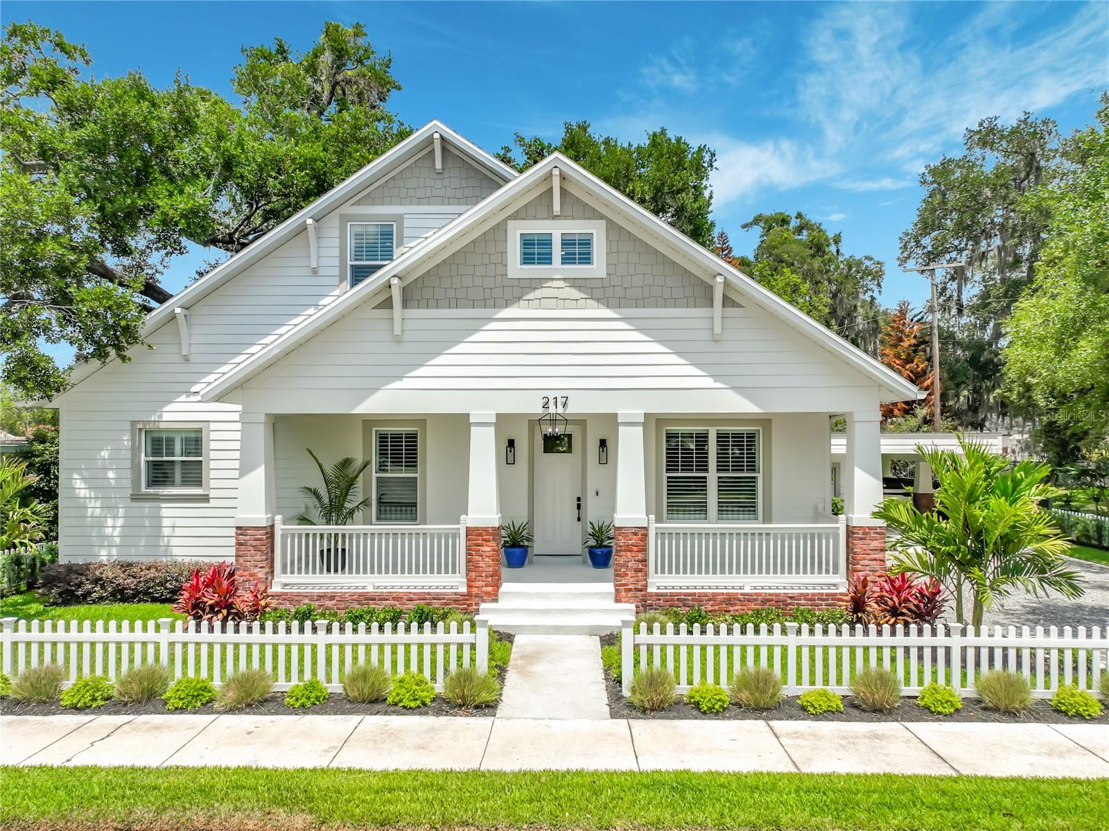 LOCATION, LOCATION, LOCATION! Experience the best of Historic Winter Garden living in this brand-new Craftsman-style home, ideally located just steps from downtown dining, shopping, entertainment, and the renowned West Orange Trail. Originally a charming 1950s bungalow, the 576 sq. ft. home has been completely renovated and thoughtfully expanded into a stunning 2,800 sq. ft. residence offering 5 bedrooms, 4 bathrooms, and exceptional modern upgrades throughout.

Relax on the inviting front porch and enjoy the charm and atmosphere of this idyllic golf cart community. Inside, a bright and spacious open floor plan welcomes you with designer finishes, 10-foot ceilings, luxury waterproof vinyl plank flooring, plantation shutters, 8-foot doors, and elegant architectural details throughout.

The heart of the home is the spectacular chef’s kitchen featuring premium LG stainless steel appliances, built-in oven and microwave, induction cooktop, wine fridge, oversized island with seating and storage, 42” refrigerator, and an enormous walk-in pantry complete with an additional retro-style refrigerator. The adjoining family room showcases a custom fireplace with built-in storage and two sets of French doors opening to a large covered lanai with summer kitchen, overlooking the beautifully landscaped and fully fenced backyard with additional deck space for entertaining and relaxing.

The luxurious primary suite offers custom walk-in closets, a spa-inspired en-suite bath, and private French doors leading to a secluded patio and deck area. A separate lower-level wing includes two additional bedrooms, a full bath, and utility room, creating endless possibilities for an in-law suite, home office, theater room, or private guest retreat. Upstairs, you’ll find two spacious bedrooms, including one with en-suite bath, an additional full bath, linen storage, and generous extra storage space.

Additional highlights include a covered carport with EV charging outlet, oversized driveway with parking for at least 6 cars, 2-zone A/C system, gutters with leaf guards, upgraded lighting, charming picket fencing, lush landscaping, and a 10x8 storage/workshop.

Live the coveted Winter Garden lifestyle with golf cart access to charming boutiques, restaurants, breweries, parks, the weekly farmers market, Lake Apopka, splash pad, and more. This exceptional home perfectly combines historic charm with luxurious modern living in one of Central Florida’s most sought-after communities. Don’t miss this rare opportunity!