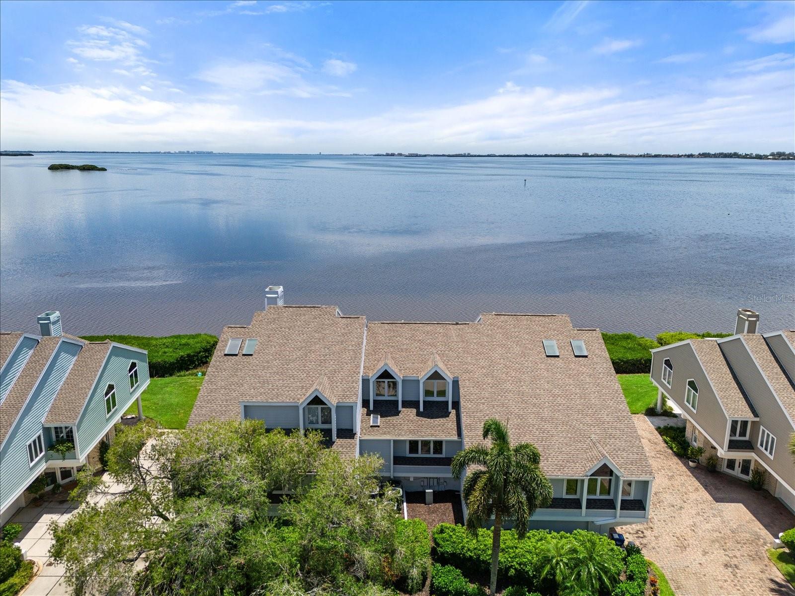 NEW PRICE- Move In Ready! Experience the ultimate in luxury living with this spectacular bayfront residence on Tidy Island, a true gem in the heart of Sarasota Bay. Transformed through an extensive renovation, this home stands out as a unique masterpiece that seamlessly blends elegance, comfort, and modern sophistication. Spanning three generous bedrooms, this home ensures ample space for family and guests. The versatile loft area serves as a perfect home office, media room, or additional guest suite, tailored to meet your specific needs. The formal living and dining rooms are designed with sophistication in mind, featuring dramatic vaulted ceilings that enhance the sense of grandeur. Multiple skylights and expansive wall-to-wall impact windows flood the space with natural light, creating a bright and airy ambiance that is both inviting and energizing. The chef’s kitchen is a culinary enthusiast’s dream, equipped with top-of-the-line appliances including a Viking gas range with a custom hood, a Sub-Zero refrigerator, dual sinks, and a separate prep sink. This gourmet kitchen is not only functional but also aesthetically pleasing, with custom cabinetry and high-end finishes that make cooking a pleasure. Custom details abound throughout the home, from the exquisite stair railings to the built-in shelving and storage solutions that enhance both style and practicality. The residence has been updated with newer A/C units to ensure year-round comfort, and is presented in move-in-ready condition, allowing you to settle in without delay. Step outside to enjoy the outdoor living spaces, including a covered open patio perfect for al fresco dining or relaxing while taking in the views while visiting with company. The property also features multiple storage areas, a spacious two-car garage, and covered guest parking, catering to all your practical needs. Situated in a prestigious, gated community with 24/7 guard-controlled access, this home offers a secure and tranquil environment. Residents have access to a wealth of amenities, including well-maintained walking trails, kayak launching areas for waterfront adventures, tennis courts, swimming pools, a wellness area, and inviting gathering spaces for socializing and community events. Conveniently located just minutes from pristine Gulf beaches, top educational institutions like St. Stephens, IMG Academy, and Bradenton Christian School, as well as Sarasota-Bradenton International Airport, this property provides the perfect balance of serene seclusion and easy access to local conveniences. Embrace a lifestyle of unparalleled luxury and make this exquisite bayfront home your own.