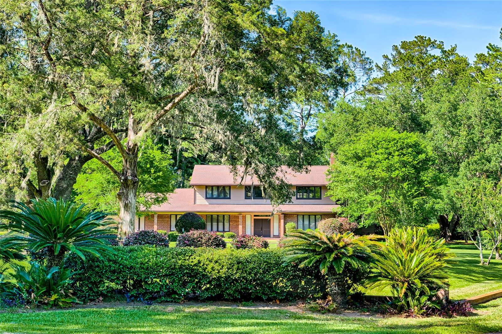 One or more photo(s) has been virtually staged. Come enjoy living in one of Gainesville's finest neighborhoods!  As you arrive after a winding drive over a creek, you will love the curb appeal of the brick lined front yard that frames this property beautifully.  Entering this home through the solid wood double doors you will be impressed with 20 foot plus ceilings.  The kitchen is the center of the downstairs and it presents great views of the pool and lush back yard from the eat in area.  With a center island and large counter top space, the chef in your life will crave to cook here. The family room is highlighted by a brick wood burning fireplace with wonderful space for all your guests and family to enjoy with grand high ceilings and second floor loft above.  The living room is ideal for your TV and comfy couches.  Adjoining the living room to the kitchen is the kitchen bar top that will handle many stools for casual dining and visiting with guests.  The master suite is downstairs and has dual vanities, two walk in closets, a linen closet and huge tub/shower.  The laundry room is connected to master bedroom for ultimate convenience.  Office is adjacent to front door on the left with great views of the huge front yard.  Going upstairs to the three kids/guest bedrooms you will find each bedroom has a walk in closet.  One bedroom has a private balcony overlooking the pool and another is connected to the loft which has the second balcony overlooking the pool.  The loft looks down at the living room and fireplace.  The upstairs bath has separate vanities that can be closed off from the tub/shower for multiple kids to have their time of privacy.  Heading outside to the upgraded cobblestone paver patio and pool, you will find big spaces for entertaining very large gatherings that will surely impress all of your guests.  A spiral staircase goes up to the balcony off the loft.  The gardens in the back yard will be enjoyable to see, the smell of jasmine in bloom and for relaxation.  Please come see a piece of Gainesville