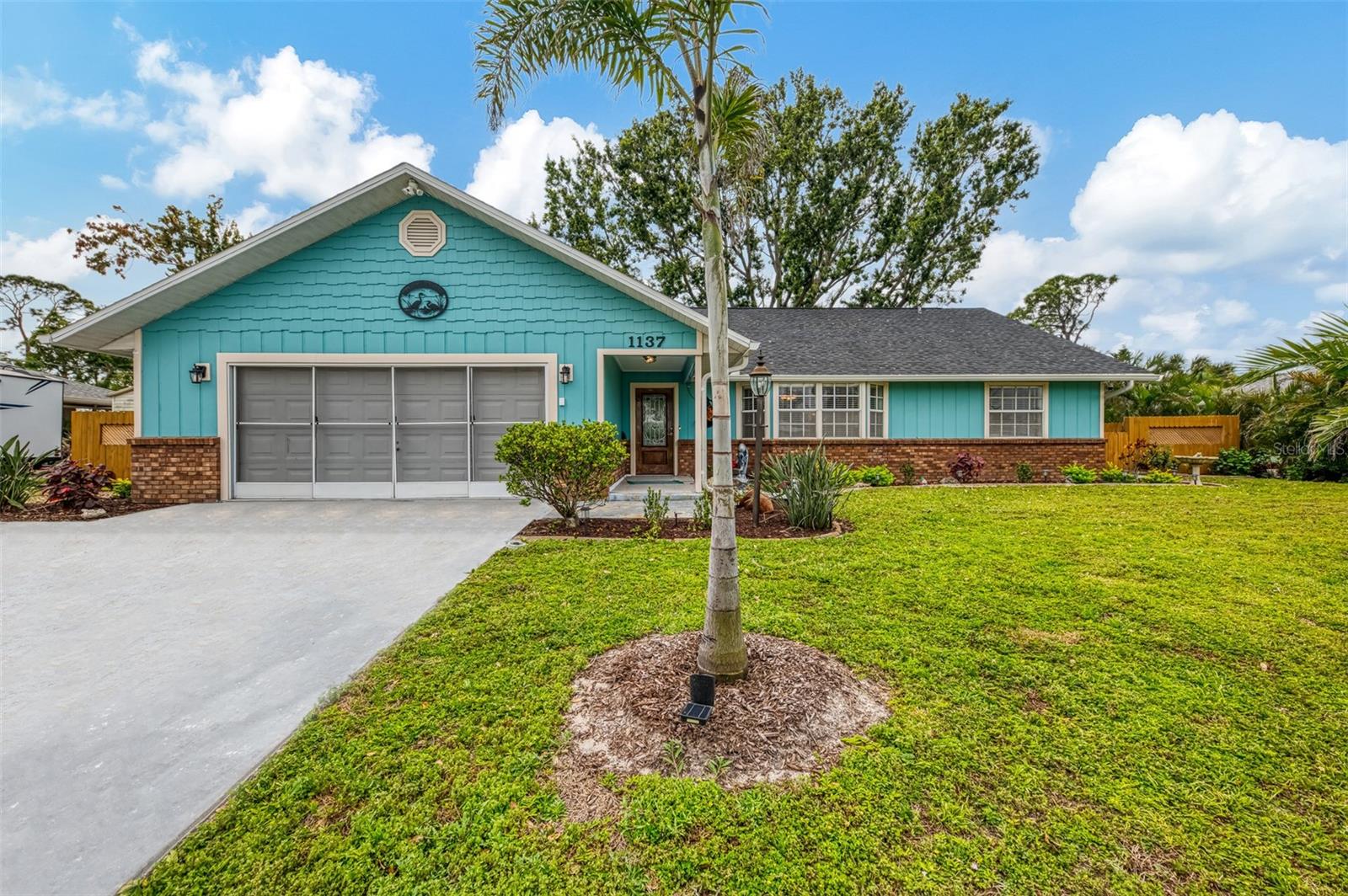 SOUTH VENICE! MINUTES TO THE BEACH! SPACIOUS, ALMOST 2000 SQ. FT UNDER AIR! 3-bedroom, 2-bath, 2-car garage custom home is full of character, thoughtful design, and fantastic UPGRADES. This home would be a perfect air-bnb having 3 bedrooms, living room, & family room! Plenty of parking too! Bonus room above the garage, large Living room, Family room, and a FENCED YARD, this home offers style, space, and functionality in a prime location minutes to Venice Beach! Step onto the cozy covered country front porch, where the peaceful sound of a private fish pond with a fountain is surrounded by lush greenery and flowing shrubs. A gorgeous leaded glass front door sets the stage for what’s inside. Soaring tall, angular ceilings and an expansive layout make this home feel open and welcoming.  Perfect floor plan for a large family! The huge 10x18 kitchen features solid WOOD CABINETS with pull-out drawers, a tiled backsplash, LED lighting, and ample counter space, including a cozy breakfast bar overlooking the dining area. The kitchen comes complete with STAINLESS STEEL APPLIANCES and a WASHER/DRYER! The floor plan flows effortlessly into a 27-ft. living room with a picturesque bay window and a 27-ft. family room with a WOOD BURNING FIREPLACE—perfect for creating a warm and inviting atmosphere. French doors lead to a spacious tiled patio, offering the perfect outdoor retreat. Can hook up the hot-tub right here! The primary suite is a true escape, boasting a 13x19 layout, a large walk-in closet, French doors to the patio, and a private ensuite with a granite counter vanity and a tiled walk-in shower. On the opposite side of the home, pocket doors provide additional privacy for the guest rooms. The second and third bedrooms (12x12 each) include ceiling fans, with the third bedroom featuring mirrored closet doors and French doors leading to the family room. The guest bathroom is designed for relaxation, offering a GRANITE COUNTER VANITY and a DEEP JETTED TUB with a shower. This home is filled with impressive updates, including a NEW ROOF, NEWER A/C, and a SOLAR HOT WATER HEATER, helping to keep energy costs low. Additional thoughtful features include KEYLESS ENTRY, a RAINBIRD IRRIGATION SYSTEM, a TOP OF THE LINE WATER SOFTENOR and irrigation designed specifically for hanging flowers in the front yard. A HOOK UP FOR THE HOT TUB IN PLACE, while the LEAF GUARD GUTTERS and backyard STORAGE SHED add even more convenience. The SCREENED GARAGE, and an EXTRA PARKING PAD provides plenty of space for guests or recreational vehicles. Located in highly desirable South Venice, this home offers optional membership to the SOUTH VENICE FERRY, giving access to a private beach, boat ramp, and kayak launch. Shamrock Park is just minutes away, offering tennis courts, basketball, nature trails, and a playground. Home is also minutes to South Venice Community park with swimming pool and more! With downtown Venice, Venice Beach, shopping, and dining nearby, this home offers a perfect blend of privacy, UPGRADES, and PRIME LOCATION. Don’t miss out on this one-of-a-kind property!