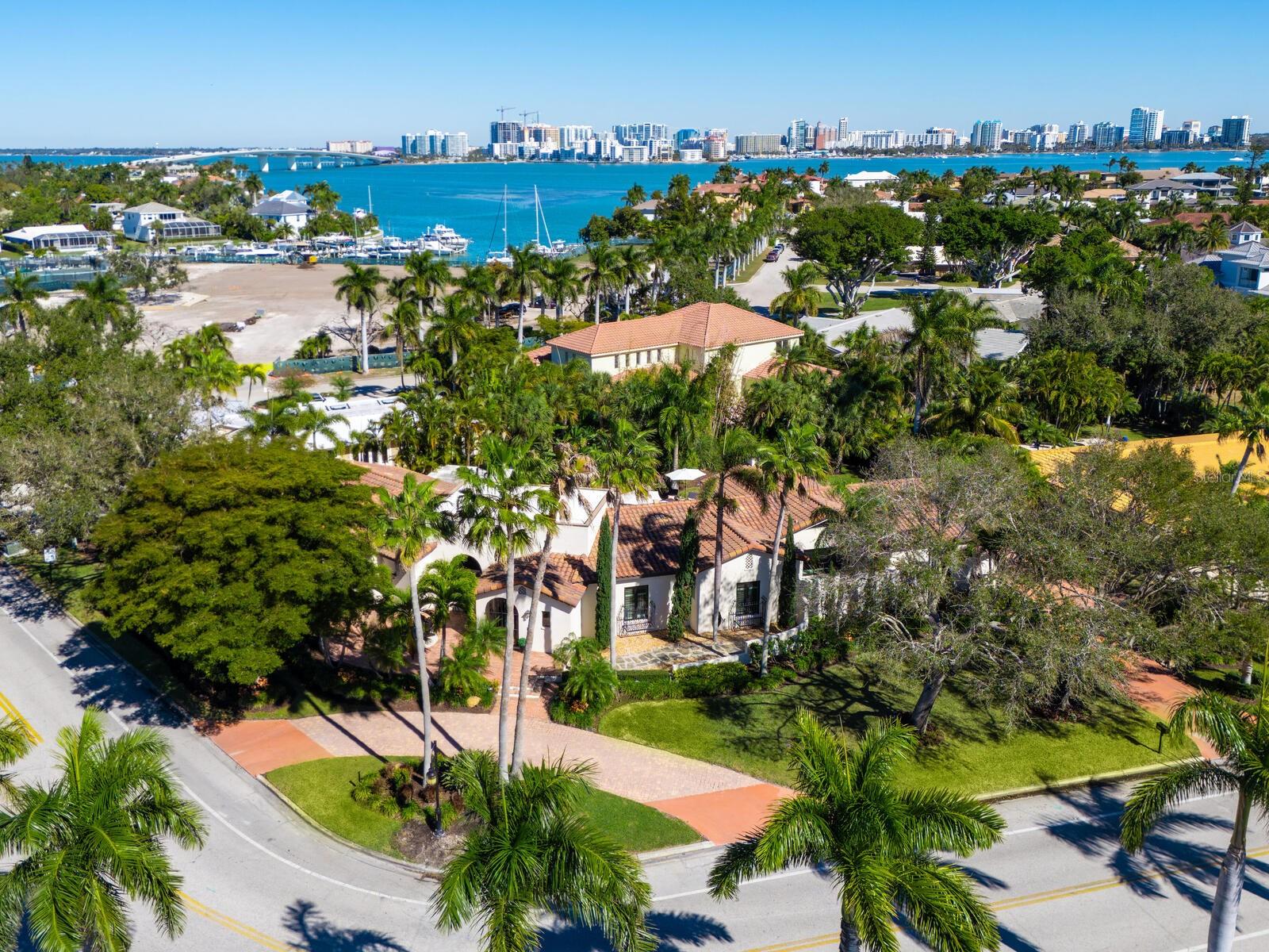 Custom built by a locally treasured builder on one of Bird Key’s largest homesites, over half an acre, this one-level Spanish Mediterranean residence delivers a rare blend of timeless design, thoughtful updates and a resort-style outdoor experience. The home’s wraparound footprint creates exceptional curb appeal while maximizing privacy and indoor-outdoor flow, opening to an expansive rear-yard sanctuary that feels straight out of Selby Gardens. Inside, intricate architectural details meet modern refinement to create dramatic volume and warmth, including soaring ceilings with beams and paneling, walls of windows and travertine flooring throughout. The home has been recently updated with features including PGT impact-rated doors and windows, updated electrical, RH light fixtures, LED accent lighting and fresh landscaping. A 2015 barrel tile roof adds enduring style and peace of mind. The chef’s kitchen is beautifully appointed with a Wolf gas cooktop, built-in oven/microwave, Sub-Zero refrigerator, icemaker, custom cabinetry with specialty slide-outs, marble and quartz counters, and a Carrera marble backsplash, all overlooking an intimate walled courtyard. Two spacious primary suites, made even more unique by a connecting playful outdoor shower, complete the thoughtful layout. Two additional bedrooms rest on another side of the home as a relaxing respite for guests. Outside, the ambiance is unmatched with an infinity-edge pool with a gas fire bowl, a covered sitting area and an expansive yard, fully enclosed for privacy, creating an entertainer’s dream and an everyday escape. Just a short distance to the marina and new Bird Key Yacht Club, and ideally between downtown Sarasota and St. Armands Circle. The feel is unmatched, so to understand this level of quality, make an appointment to see it today.