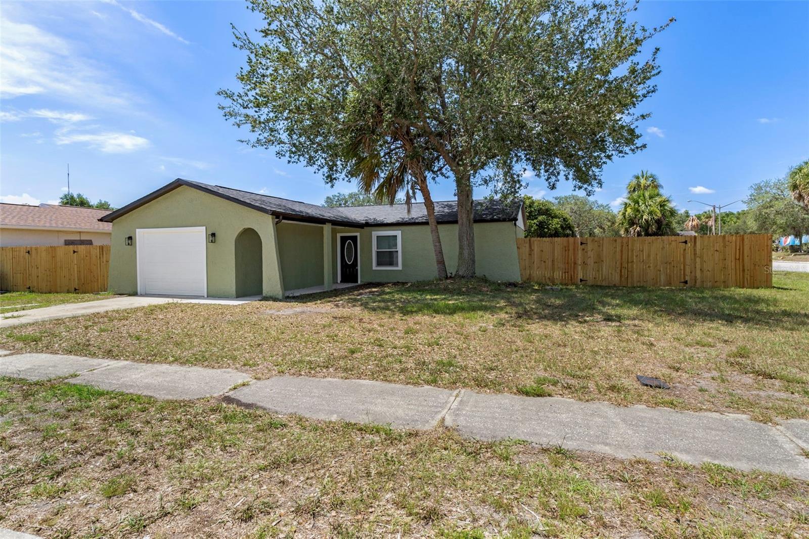 Virtually Staged. Absolutely stunning 2 bedroom 2 full bathroom, fully fenced in corner lot, home located in the heart of Hudson FL where everything has already been done for you including 2026 ROOF. Your 2 bedroom, 2 bathroom split floorplan home has been thoughtfully and thoroughly updated from top to bottom, offering a clean, modern feel the moment you walk through the door. (2026 ROOF, 2026 Remodel) Inside, you are greeted by a bright and open layout featuring new flooring, fresh interior paint, impressive lighting, and updated trim throughout. Walk on over to the kitchen of your dreams!! Complete with real wood cabinetry, with soft close features, equipped with premium stainless steel appliances, gorgeous quartz countertops, along with a show stopper backsplash tile, providing both quality craftsmanship and everyday functionality. Your kitchen boasts a breakfast bar with views of your spacious backyard, along with the ability to entertain and interact with guests. Both bathrooms have been completely remodeled from top to bottom with premium modern finishes. Your guest bathroom has more than enough room, and boasts a brand new vanity with gorgeous quartz countertops, along with a tub/shower combo. Your primary suite bathroom is just as impressive with floor to ceiling, tile in the shower. Both bathrooms feature a full body shower tower that will leave you mesmerized. Extra care and high end finish carpentry is evident throughout, giving the home a cohesive and updated design. Major upgrades including a brand NEW 2026 roof along with 2018 upgraded windows provide long term peace of mind and energy efficiency. If the home doesn't take your breath away, your backyard will, step outside to your fully newly fenced backyard, where you will find peace and plenty of space to relax or entertain. There is also additional space in the backyard ready for customization, whether you choose to create a shed, playhouse, or pet area.  Located close to shopping, dining, and everyday conveniences, this home offers the perfect mix of modern updates, functional space, and future potential. Come on over and explore all the possibilities this move in ready home has to offer. (2026 ROOF, 2018 Windows, )