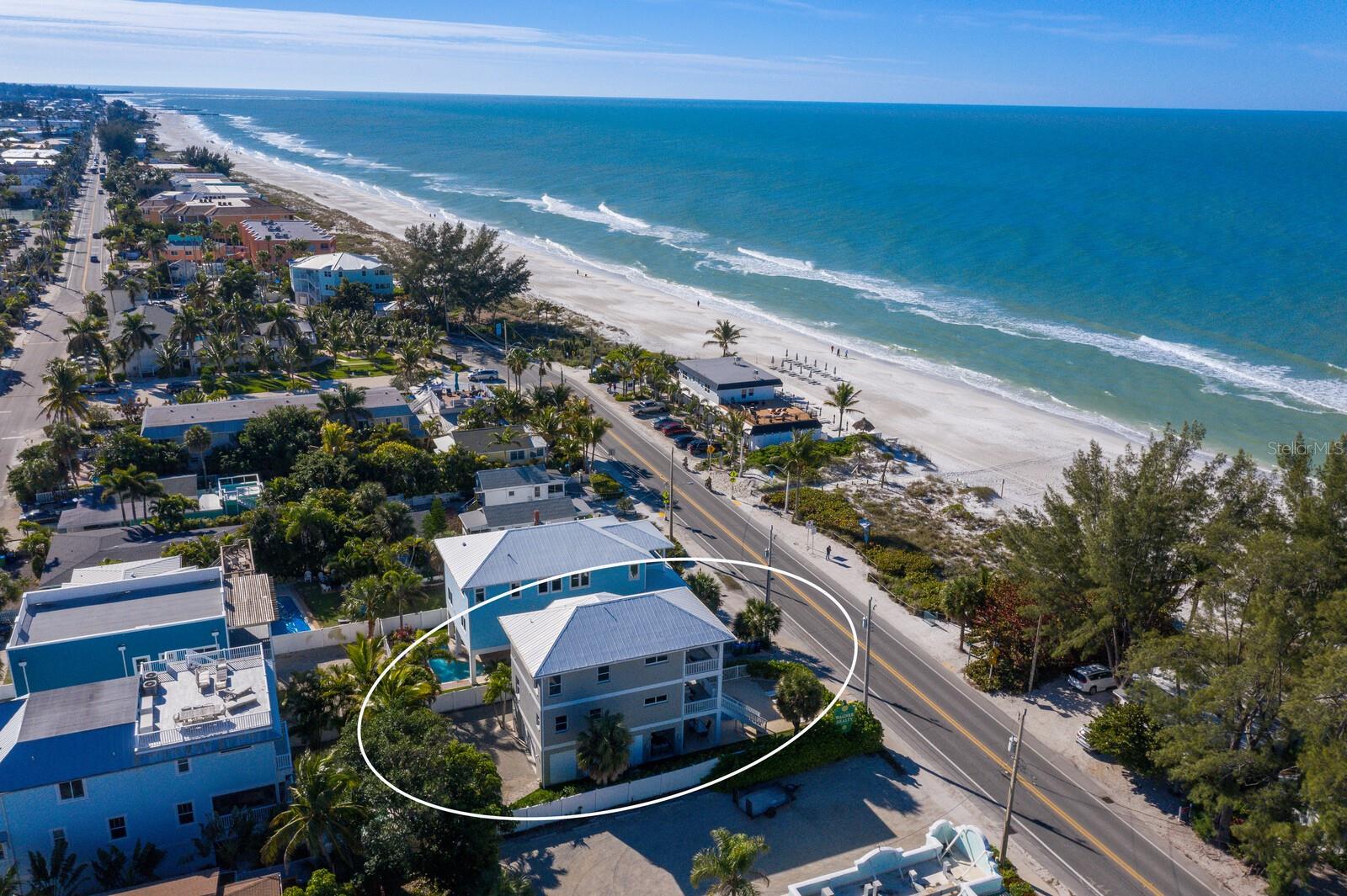 One or more photo(s) has been virtually staged. STUNNING BEACH HOUSE WITH FULL GULF VIEWS!!! ONLY 10 STEPS FROM THE PROPERTY TO YOUR FEET IN THE SAND!!! ONE OF THE NICEST HOMES YOU WILL EVER FIND WITH ENDLESS GULF VIEWS IN THIS PRICE POINT!  Prepare to capture breathtaking moments as you immerse yourself in the splendor of this spectacular 3-bedroom, 3-bath turnkey furnished home. Nestled just across the street from a beachfront park, the property offers UNOBSTRUCTED VIEWS that will leave you in awe. From the moment you pull into the paver brick driveway you will feel the stress of life melt away in this coastal retreat. Tropical landscaping, the sounds of the waves and endless sunsets will provide full relaxation. This ideal family vacation home boasts two spacious beachside porches, a putting green a private heated pool for your enjoyment year round. The three-story island paradise offers a great room floor plan that is perfect for entertaining. The large dining room is next to the chef's kitchen equipped with stainless steel appliances, a spacious center island with a breakfast bar and plenty of cabinet space which makes this home perfect for gatherings.  The serene master bedroom offers endless views of the turquoise water, sitting area, ensuite bathroom and a private scenic porch. The second and third bedroom provide the perfect space for friends and family to visit. The refinished hardwood floors throughout add to the coastal ambiance.  Explore the vibrant Bridge Street with its charming shops and restaurants, and take advantage of the nearby marina for all your boating needs. This property offers an exceptional investment opportunity, with projected rental income available upon request. Whether you choose to make this your permanent residence or an income-generating vacation home, every day will feel like a vacation as you immerse yourself in the coastal lifestyle. Don't miss the chance to own this exquisite piece of paradise in Bradenton Beach.