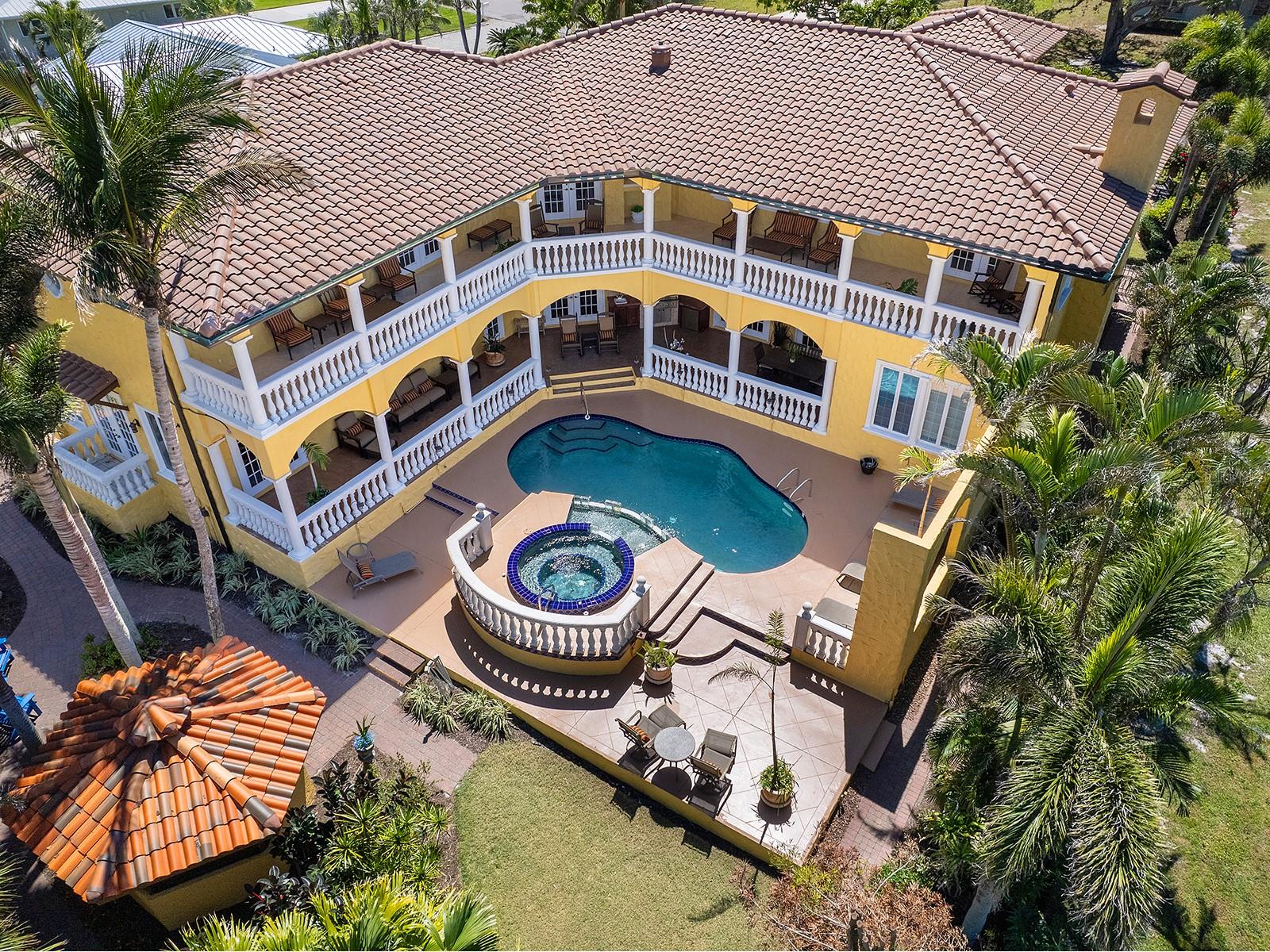 Step into an architectural masterpiece on Venice Island, where craftsmanship, global design, and grand-scale living converge. This custom-built estate spans over 5,000 square feet and is anchored by a true restaurant-style kitchen - a rare feature in residential luxury - complete with a commercial gas stove and broiler, restaurant-grade sinks with rinse-down hose, floor drain for full wash-down capability, double warming drawers, dual sinks each with garbage disposals, and a full refrigerator/freezer setup designed for high-volume entertaining and professional-level performance. Designed with intentional separation, the kitchen features a classic swinging restaurant door that discreetly divides it from the main living spaces, along with a second private entry from the garage, allowing seamless service flow and behind-the-scenes preparation - keeping entertaining polished, effortless, and uninterrupted for guests. From the moment you arrive, the grand circular governor’s driveway crafted with brick pavers sets the tone for the sophistication within. Stunning custom Honduran red mahogany double front doors open to reveal a breathtaking interior where Italian floor tiles and Spanish marble create a seamless fusion of opulence and warmth. Custom iron railings, masterfully crafted in Berlin, accentuate the architectural beauty, while exquisite stained glass windows cast a mesmerizing glow throughout the home. The residence offers dual primary suites, one on each level, delivering exceptional privacy and flexibility. The upstairs retreat is accessed by a private custom spiral staircase and both levels feature sweeping double-decker balconies spanning the width of the home, overlooking the resort-style heated saltwater pool, spa, and gazebo. Peek-a-boo views of Robert’s Bay await from the second-story balcony. Additional highlights include a private library with wet bar and gas fireplace, a private gym with en-suite bath, a bath with direct access to the pool, and an oversized three-car garage. Infrastructure upgrades include filtered drinking water throughout the entire home, a new roof, two water heaters, three air-conditioning units, a 500-gallon underground propane tank, whole-house sound system, Lutron system, and integrated security system. Impact glass windows and doors, along with a whole-house generator, provide peace of mind year-round. Set on a .31-acre elevated lot and, according to the owner, never having experienced flooding, this estate stands as a testament to superior construction and prime Venice Island positioning. Originally designed as an entertainer’s paradise, the home has hosted political and social events alike, offering a level of scale, function, and presence rarely found.
This is not simply a residence - it is a legacy property. View this architectural marvel today.