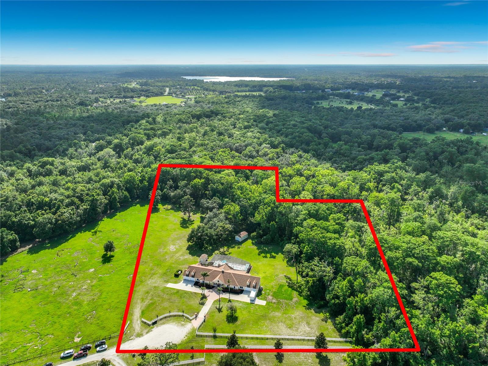 Spacious Multi-Generational Estate on 6+ Acres in charming Chuluota! Custom single-story POOL home with 8 bedrooms and 6.5 baths at the end of a quiet cul-de-sac is available for immediate occupancy! This fenced, horse-friendly property features 2 primary suites with pool access on one side, and a private Mother-In-Law suite (with living room, bedroom, full bath, exterior, garage & pool entries) on the other. Convenient dual kitchenettes and laundry rooms serve each wing with 5 additional bedrooms throughout the home. Meticulously updated for ultimate peace of mind: NEW ROOF (April 2026), Stainless kitchen appliances (May 2026), Quartz kitchen counters (2025), and updated wing flooring (2025). Mechanics include a whole house re-pipe (2023), iron/sulfur ozone filtration system (2025), septic replaced (2018/pumped 2026), and a serviced Generac generator (March 2026). For added peace of mind, the property is covered by a preventative subterranean termite protection bond with Sentricon bait stations, which may be renewed by the buyer in May 2027. The expansive backyard is built for entertaining, showcasing a custom pool and heated spa with a bubbler shelf and deck jets. Host unforgettable gatherings on the massive pool deck, complete with a summer kitchen bar and a grand, over-sized screen enclosure with a serene wooded view. Don't miss this rare opportunity to own a turnkey, versatile estate with room to grow. Take the virtual tour or schedule your private showing today! Equal Housing Opportunity.
