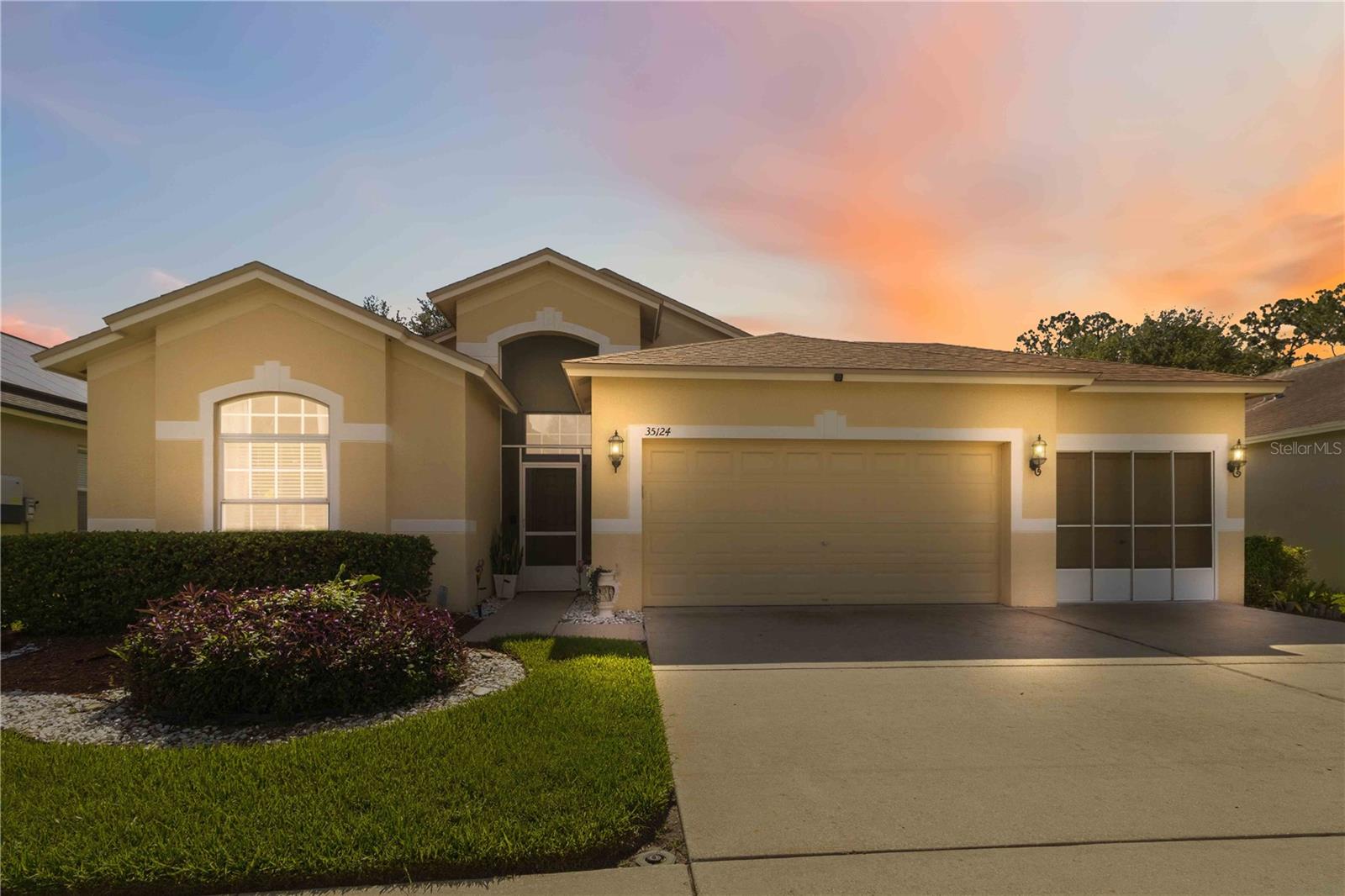 Escape to your own slice of Florida paradise at 35124 Deerfield Oaks Drive, a captivating sanctuary in the heart of Zephyrhills' premier golf-course community, Lake Bernadette. This home welcomes you with its pristine stucco facade, manicured landscaping, and a spacious two-car garage uniquely equipped with a sliding screen enclosure—the ultimate luxury for enjoying a bug-free afternoon cross breeze. 

Designed with a masterful layout, the home features a spacious four-bedroom, two-bathroom split floor plan that flows effortlessly from the front door. Positioned just off the welcoming foyer is a formal dining room that provides an elegant backdrop for holiday dinners and celebrations, highlighted by high vaulted ceilings and a stylish tiered chandelier. The true social center of the home is the expansive great room, which serves as a spectacular main gathering space. This central living room boasts durable ceramic tile flooring, a central ceiling fan, and architectural plant shelves that add vertical drama and an open, airy ambiance.

The great room transitions seamlessly into the kitchen, thoughtfully designed to act as both a functional workspace and a social hub. Home chefs will appreciate the abundance of rich dark espresso cabinetry, beautifully accented by a multi-toned mosaic tile backsplash and solid, expansive countertops. Complete with modern stainless steel appliances—including a French door refrigerator—the kitchen also features an integrated corner pantry for easy storage and a wide breakfast bar that invites guests to pull up a barstool. Tucked right next to the kitchen is a bright breakfast nook, providing a cozy, informal spot for morning meals.

When it is time to unwind, the split-bedroom layout provides exceptional privacy across the home's distinct wings. The serene primary suite serves as a tranquil retreat featuring soft coastal blue walls, wide wood-look laminate flooring, and a large window that floods the space with natural light. The spa-like en-suite primary bathroom features a long double-sink vanity with dark cabinetry, an expansive mirror, a dedicated knee-space dressing station, and a deep garden soaking tub situated under a bright window. The remaining three bedrooms are generously sized and split from the primary suite, providing a perfect arrangement for guests, and flexibility.

An incredible indoor-outdoor lifestyle is achieved effortlessly at the back of the home, where glass doors lead out to a massive, fully screened patio enclosure, creating a protected outdoor living room ideal for al fresco dining or lounging in the shade. Positioned directly on a peaceful, shimmering pond, this scenic sanctuary features a custom red-mulched landscape bed with a cozy bench station, offering a front-row seat to spectacular waterfront views and local wildlife.

Lake Bernadette grants you access to an enviable lifestyle anchored by a premier clubhouse with a fitness center, community room, playground, lighted tennis/pickleball courts, and two swimming pools, including a heated pool. Situated with easy access to State Road 54 and Interstate 75, commuters have a direct route to downtown Tampa and Lakeland. This prime location also puts you just a short drive from Wesley Chapel's premier shopping at the Wiregrass Mall and Tampa Premium Outlets, top-tier medical facilities like AdventHealth Zephyrhills, local schools, parks, and natural springs.