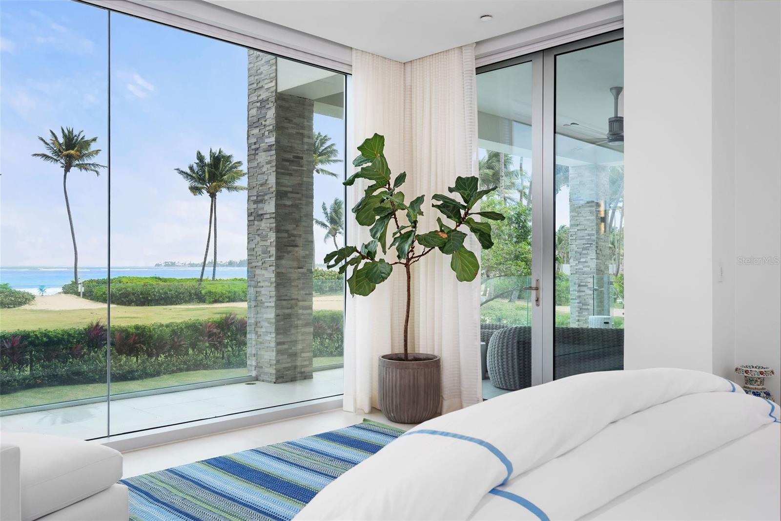 Supreme Beachfront Luxury in the St. Regis Bahia Beach Resort – Within Puerto Rico’s most exclusive resort, discover this move-in ready, coveted beachfront corner villa in the unparalleled Ocean Drive Residences. With 3 bedrooms and 3.5 bathrooms, sweeping ocean views, private salt-water swimming pool and jacuzzi, nowhere else will you find a more breathtaking property on the beach. Imagined by renowned architectural firm SB Architects and designed by global firm Hirsch, Bender, and Associates, premier luxury awaits you in every corner of this immaculate, fully furnished, turn-key condo. Floor-to-ceiling windows in every room maximize light and ocean exposures over the residence’s 4,777 square feet of gross living area.  Open plan kitchen and living room features jaw dropping views of Puerto Rico’s most beautiful half-moon white sand beach. The well-appointed Poliform Italian kitchen is outfitted with top-of-the-line Sub-Zero and Wolf appliances. A neutral color palette compliments the over-sized white quartz island and countertops. Custom cabinetry above the bar area makes for fabulous entertaining. The living area connects directly to the expansive covered terrace and dining area, boasting 1,400 square feet and including a state-of-the-art Wolf outdoor kitchen and grill. Outfitted with iPad synced SmartHome system, Lutron audio, and Sonos speakers throughout the home and pool area- every detail of contemporary luxury is considered. From the moment you wake, tremendous ocean views greet you from bed - the master suite features floor-to-ceiling hurricane proof glass walls. Step out directly onto the grand balcony and enjoy the ocean breeze. The enormous primary ensuite bathroom includes a standing tub, double vanity, and sauna showers. His-and-her closets have been outfitted by Italian brand Sangiacomo with custom lighting and mirrors. The same attention to detail transitions into the secondary suite where two full walls of glass line the bedroom. The standing tub in this ensuite bathroom features unique concentric circle design and sauna shower. The third bedroom suite features a unique back patio with a green wall maximizing privacy and perfect for taking in the sunsets or reading a book. Walk directly from your home out onto the enclosed pool and yard area or venture mere meters to the secluded white sandy beach, which stretches nearly 2 miles. Store your beach equipment or sports gear in the convenient 136 square foot storage included with the purchase. 

Bahia Beach is an outdoor lover’s paradise - residents can explore a host of lakes and rivers sprawling over its 400-plus acres. The resort is home to a Certified Gold Audubon International Signature wildlife sanctuary. Walk, jog, or bike along the nature trails that run throughout the beautiful grounds. Golf on an astonishing course, designed by renowned architect Robert Trent Jones Jr., with views of El Yunque Rainforest from nearly every hole. Tennis aficionados can choose either hardtop or clay courts. From the nearby Boat House, residents can kayak along the Espiritu Santo River, paddle board, catch-and-release fish, or sail. Dine in one of the many gourmet restaurants located at the hotel or visit the newly planted hydroponic garden - residents can order fresh organic produce delivered right to their door. This is luxury living at its finest. 
Property is sold with all furniture, 2 parking spaces, 1 electric charging station, a 2021 Tesla Model Y, and 6 passenger golfcart.
