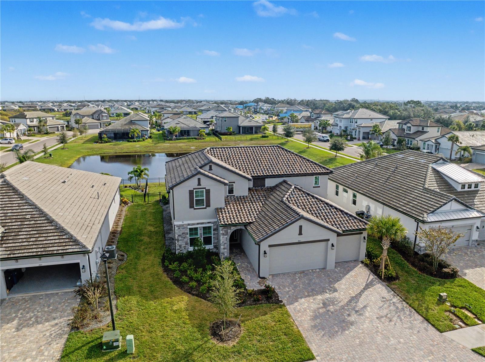 Welcome to a refined luxury residence in the gated community of Sweetwater at Lakewood Ranch, where modern elegance, spacious design, and high end upgrades come together to create an exceptional place to call home. As you enter the soaring two story foyer, abundant natural light and clean architectural lines set the tone for the rest of the home. The open concept living area offers beautiful lake views through oversized sliders and flows effortlessly into the dining room and gourmet kitchen. This stunning kitchen features a large island, upgraded cabinetry, quartz countertops, stainless steel appliances, a polished tile backsplash, under cabinet lighting, and a walk in pantry, making it ideal for both everyday living and entertaining. Upstairs, a spacious loft provides the perfect second living area for a movie lounge, game room, office, or retreat. The primary suite feels like a private sanctuary with serene natural light, two walk in closets, and a spa inspired bathroom complete with an oversized walk in shower, a soaking tub, upgraded tile, and dual vanities. All additional bedrooms are generously sized, offering comfort and flexibility for guests, family, or a home workspace. The entire home reflects a calming coastal palette, luxury flooring, and meticulous attention to detail. Outdoor living is equally impressive, featuring peaceful lake views and a fenced yard perfect for relaxing mornings or sunset evenings. Residents of Sweetwater at Lakewood Ranch enjoy a resort style lifestyle with incredible amenities including a fitness center, sparkling pool, pickleball courts, a playground, walking paths, and a secure gated entrance. This home offers the perfect blend of comfort, luxury, and convenience just minutes from top rated schools, shopping, dining, medical facilities, golf courses, and the world renowned Gulf Coast beaches.