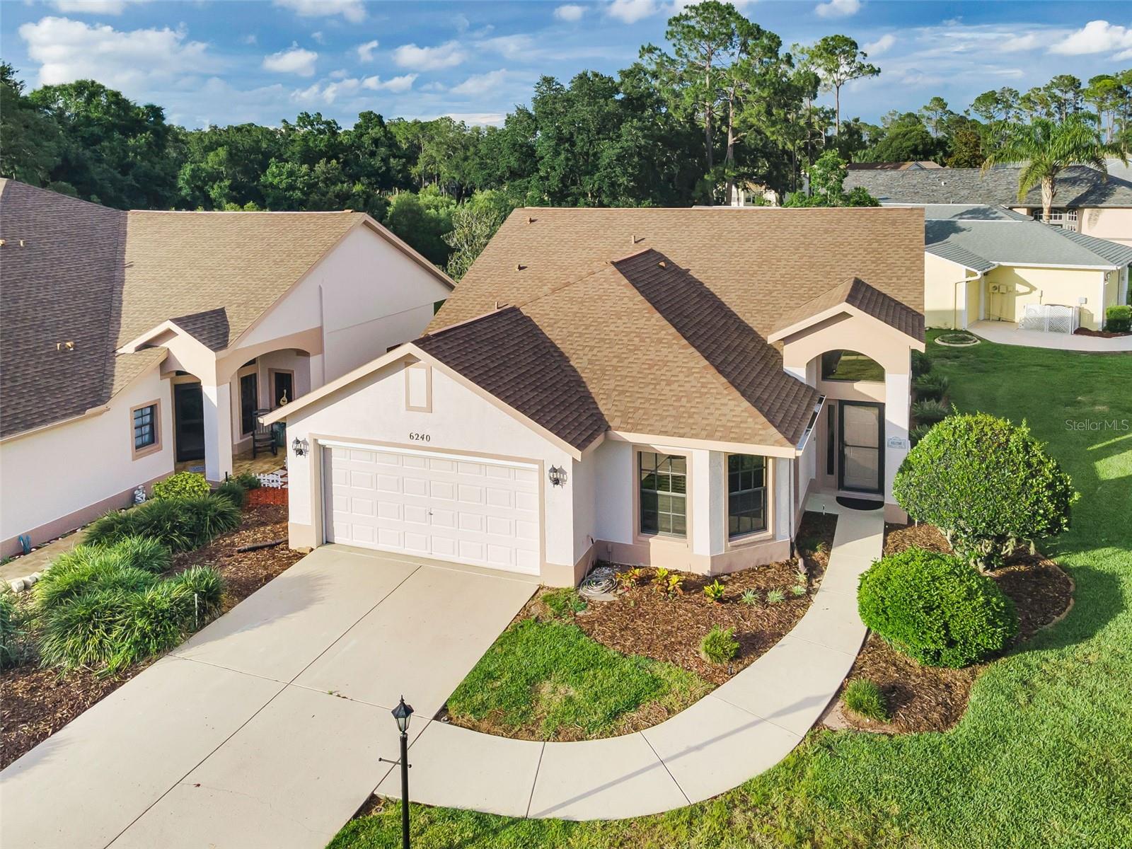 IN TIMBER GREENS A 55+ GATED GOLF COURSE COMMUNITY.... A RARE FIND...A STUNNING UPDATED STAND-ALONE VILLA ON A CORNER LOT LOCATED ONLY A BLOCK AWAY FROM THE CLUB HOUSE .... This 2+ Bedrooms... An EXTRA ROOM COULD BE USED FOR AN OFFICE OR DEN -bedroom 2 bath 2 car garage ...is a rarity.... ALL REDONE...New LUXURY VINYL FLOORING FLOWING THROUGH OUT HOME. Newly painted inside. Kitchen with granite counter tops, recess lighting, breakfast bar. Large ensuite with walk-in closets. Primary bath and guest Bath Completely redone with New quartz counter tops in bathrooms and floors and more. The open floor plan creates a bright, airy atmosphere that flows effortlessly from room to room, perfect for entertaining friends or simply enjoying your daily routines without unnecessary barriers. Natural light fills the living areas, highlighting the home's contemporary finishes and making every corner feel inviting. Inside Laundry room with utility sink. Motorized GARAGE SCREENED DOOR, Outside Screened in Lanai.