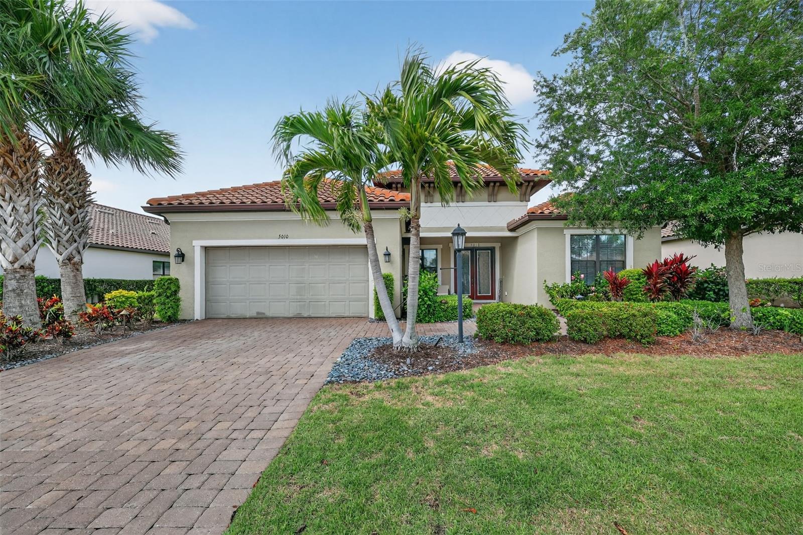 THIS IS A GOLF DEEDED HOME! TURNKEY!!  Welcome to 5010 Tivoli Run, an elegant 3-bedroom, 3 full bathroom and half bath single family home with a den, offering nearly 3,000 square feet of thoughtfully designed living space. From the moment you enter, you are greeted by 10 ft ceilings, 8 ft doors, coffered ceilings, and crown molding that create a sense of openness and sophistication throughout. The home features multiple living spaces including a formal living area, family room, and dining room, ideal for both entertaining and everyday living. The living room showcases a striking stone accent wall with a fireplace, while the family room mirrors this design with its own stone feature wall, adding warmth and visual continuity. The main living areas are finished with wood laminate flooring, complemented by tile in the bathrooms and plush carpet in the guest bedrooms. The primary suite offers a refined retreat with wood laminate flooring and a spacious ensuite bath featuring dual sinks with a built-in make-up vanity, a relaxing garden tub, and a separate shower along with custom closets. Step outside to a spacious screened lanai complete with an outdoor kitchen, perfect for hosting gatherings or enjoying quiet evenings. This 3-bedroom single family home at 5010 Tivoli Run combines elegant design elements, functional living spaces, and inviting outdoor features to create a refined and comfortable lifestyle. Esplanade offers a wide array of amenities and activities such as an 18-hole championship golf course, two resort pools, hot tubs, resistance pool, pickleball, tennis, bocce ball, two fitness centers, exercise classes, two dog parks, firepit, spa/salon, an on-site lifestyle director, social events, and various clubs plus a Tiki bar. The state-of-the-art Culinary Center offers residents several dining options such as the Barrel House as well as wine tastings, and special events.