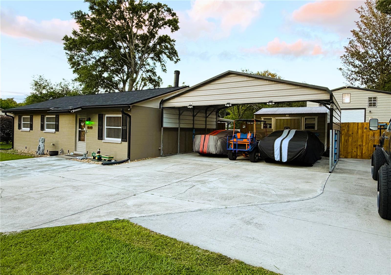 Enoy the High Springs lifestyle in this solid, move-in-ready concrete block haven with NO HOA! Perfectly positioned about 1 mile from downtown and directly across the street from the paved trail running from Poe Springs to downtown’s historic shopping and dining district. This home places crystal-clear springs and outdoor adventures right at your doorstep. Enjoy quiet, small-town charm while staying an easy 25-minute commute to Gainesville, UF, and Shands Hospital, and just 30 minutes to Lake City. This updated property effortlessly qualifies for Conventional, FHA, VA, and USDA financing.
The property is a custom dream setup for hobbyists and outdoor enthusiasts. A generous layout of freshly poured concrete provides extensive parking for your vehicles or trailers, leading to an extra-large detached workshop/garage. Keep your gear organized and protected with a multi-car carport and an additional detached storage shed featuring custom interior shelving. Outdoor living is easy with this spacious backyard completely enclosed by privacy fencing, a concrete covered patio great for hanging out.
Inside is comfortable with maximum energy efficiency. Stay cool with brand-new HVAC, entirely new ductwork, ceiling fans, New roof and thick blown-in attic insulation keeping utility bills remarkably low. The bright interior features double-hung vinyl windows that tilt downward for easy cleaning, and a refreshed bathroom complete with a new vanity, toilet, and lighting. The heart of the home features freshly painted wood cabinets, a new sink, faucet, and a clean stove and refrigerator. Backed by a brand-new hot water tank and a newly replaced septic drain field this fortified block home offers long-term durability and maintenance-free living built to last. Schedule your tour today!