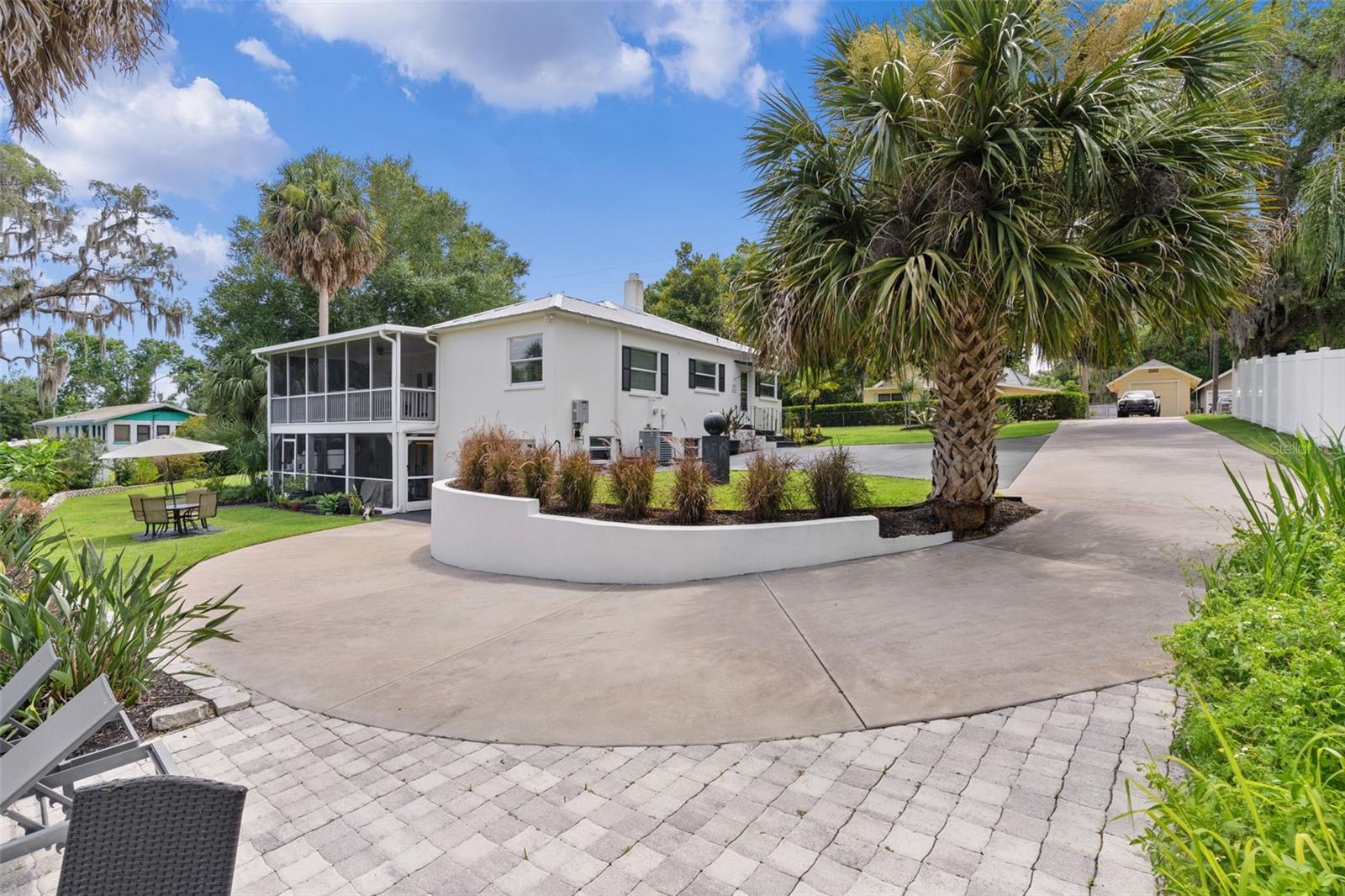 Nestled on a beautifully landscaped, high-elevation homesite just a short walk from downtown Mount Dora, this one-of-a-kind home offers the perfect blend of timeless character and modern updates while maintaining exceptional privacy. Thoughtfully renovated, the home features a 2019 metal roof (under warranty), energy-efficient hurricane impact windows and doors, completely updated electrical and plumbing systems, an on-demand gas tankless water heater, and a new A/C system installed in 2014 with additional upgrades completed in 2021. A professionally installed irrigation system supplied by a 5 HP well pump keeps the grounds lush, while the attic has been insulated with organic foam to improve energy efficiency and reduce interior temperatures.

Inside, you'll find a remodeled kitchen with granite countertops, glass-front cabinetry, pantry storage, and a charming eat-in area that flows into the spacious living room and formal dining room. The dining room showcases unique vaulted ceilings, while the living and dining rooms are accented with crown molding and beautiful arched doorways that preserve the home's classic charm. The main-level bathroom features gorgeous original tile, a tub/shower combination, and an updated vanity. Both main-level bedrooms include original built-in closets and private access to the screened 12x25 upper porch overlooking the tranquil organic garden, which has been maintained without pesticides or herbicides. The lower level, completely remodeled in 2022, offers exceptional flexibility with two additional bedrooms, a full kitchen, and an updated bathroom with a tub/shower combination and new vanity, making it ideal for guests or multigenerational living. Also downstairs is a dedicated soundproof movie theater that conveys fully furnished with a six-seat Italian leather sofa, Sony OLED television, Dolby Atmos surround sound system, acoustic panels, tables, lamps, and oversized beanbags for the ultimate entertainment experience. Step outside to the expansive 26x14 screened porch with painted concrete flooring and enjoy the peaceful surroundings. Additional features include all new interior doors, a security gate, professional monitored alarm system with glass-break and door sensors utilizing a radio transmitter system, new outdoor floodlights, a 22x15 garage, and extensive landscaping improvements. Enjoy walking to downtown Mount Dora's shops, restaurants, waterfront, and festivals while still enjoying the privacy and beauty of your own secluded property.