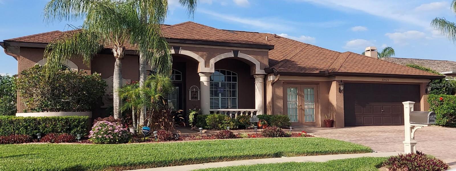 Live the ultimate Florida lake life in this stunning one-of-a-kind custom-built home. Situated on a 1/4-acre lot with no CDD fees, this exceptional residence offers approximately 2,881 total square feet of living space (2,359 sq ft main living area plus a 522 sq ft bonus room) and features direct access to a beautiful natural lake with your own private sand beach and 250 sq ft dock — perfect for boating and fishing.
This custom home boasts 4 bedrooms and 3 full bathrooms with thoughtful upgrades throughout. As you enter, you’ll appreciate the tile and laminate flooring (no carpet anywhere), a formal dining room, a formal living room, and a spacious family/TV room. The gourmet eat-in kitchen shines with granite counters, LG stainless steel appliances, and a skylight in the kitchen/pantry hallway. Just off the kitchen, a dedicated 200 sq ft office provides a quiet workspace away from the main living areas.
The luxurious master suite offers His and Her closets along with a spa-like master bath featuring a jetted tub, steam shower enclosure, and a Washlet bidet toilet.
The home also features a versatile multi-use 522 sq ft Bonus/Theater Room with stunning lake views, a 3D projector with remote-controlled 110” roll-down movie screen, and a storage closet with a separate entrance. This flexible space is ideal for movie nights, a home office, guest suite, game room, or additional entertaining area.
Throughout the main living area you will find an elegant fireplace with decorative woodwork mantle, granite surround and brick detail, a casual entertainment bar area, a laundry room with premium LG washer and dryer, and utility sink and cabinets. The home also includes a tankless electric water heater and a 6-ton A/C system with UV sanitizer.
The true highlight of this home is the spectacular waterfront pool area. Step outside to your private resort-style backyard oasis on the natural lake. Enjoy a solar-heated, salt-chlorinated pool with a beautiful natural rock waterfall, a fully screened lanai with pavers, and a 5-person Jacuzzi with cover. There is a full outdoor kitchen with gas BBQ, electric cooktop, granite counters, sink, and cabinetry. Multiple entertainment areas include a 200 sq ft deck with SunSetter retractable awning, a 400 sq ft covered party deck under a pergola with roof, and an additional SunSetter awning. The professionally landscaped grounds feature concrete curbing, flower beds, an automatic sprinkler system, rain gutters, and a Tesla Generation III charging station.
Built for Florida living, this home includes full hurricane protection with 3M film on all windows, electric hurricane shutters, and ballistic fabric for the entry doors. It is also generator-ready with an exterior hookup and panel bypass, features a 50-year dimensional shingle roof, and offers a 3-car driveway, 2-car garage, paved walkway, and front porch.
This rare custom lakefront property perfectly blends luxury, functionality, and incredible outdoor living in the desirable Lutz area. It is also just a short drive to the Tampa Premium Outlets, The Grove at Wesley Chapel (Krates), and major interstates. Schedule your private showing today and experience this unique waterfront lifestyle for yourself.