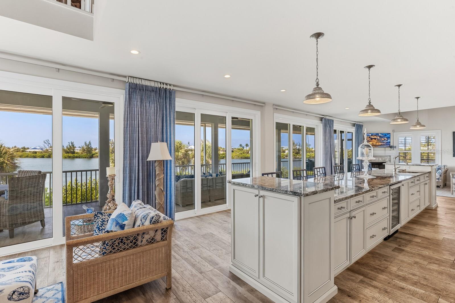 A rare and remarkable opportunity in the exclusive Seawatch community of Boca Grande, this fully reimagined lakefront residence offers the space and feel of a custom estate with the ease of coastal living. Originally two villas, this home was masterfully combined and rebuilt from the studs in 2017, creating a seamless five-bedroom, five-and-a-half-bath retreat designed for both luxury and livability. From the moment you enter, expansive living spaces unfold with walls of glass—four sets of triple-panel sliders frame tranquil lake views and invite natural light to pour in. Wood-look tile flooring, crown molding, and plantation shutters elevate the interiors, while thoughtful details throughout reflect the quality of the renovation. The gourmet kitchen is a true showpiece, featuring Patagonia granite countertops, equipped with a Wolf range, wall oven, and microwave, a Sub-Zero cabinet-front refrigerator, wine refrigeration, a warming drawer, and an additional prep sink—perfectly suited for entertaining on any scale. A massive island anchors the space, complemented by abundant cabinetry and exceptional storage throughout the home. The primary suite is a private sanctuary, featuring dual spa-inspired bathrooms, an oversized walk-in closet, and two sets of four-panel sliders that open to peaceful water views. Each additional bedroom offers comfort and privacy, making the home ideal for hosting family and guests. Modern systems—including hurricane-impact windows and doors, tankless propane water heaters, and a full gutter system—provide peace of mind, while the outdoor spaces are designed for effortless enjoyment with a propane-ready patio and seamless indoor-outdoor flow. Seawatch is a prestigious waterfront enclave of just 49 residences, thoughtfully positioned between the Gulf of Mexico and Lake Gasparilla. Residents enjoy exclusive amenities including access to the pristine Gulf shoreline, two community pools, and two tennis courts. This rare setting delivers a true barrier-island lifestyle—minutes from the charming village of Boca Grande for boutique shopping, fine dining, and world-class fishing and shelling.