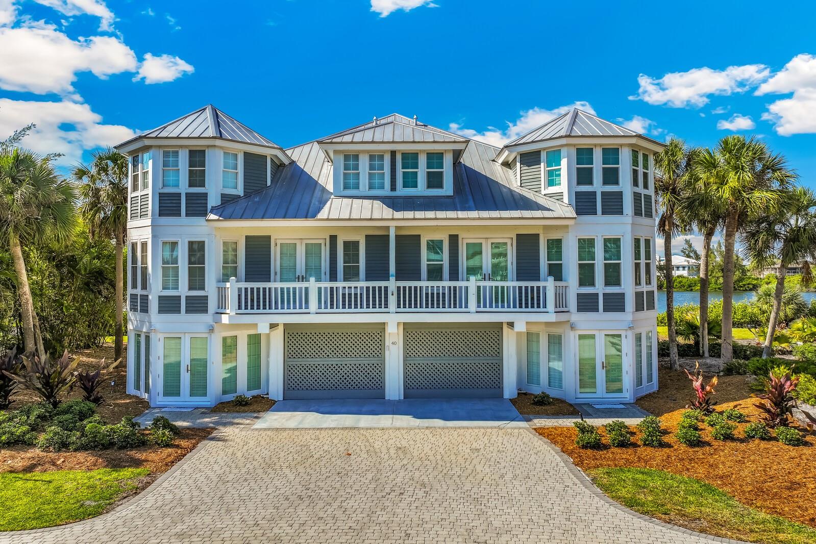 A rare and remarkable opportunity in the exclusive Seawatch community of Boca Grande, this fully reimagined lakefront residence offers the space and feel of a custom estate with the ease of coastal living. Originally two villas, this home was masterfully combined and rebuilt from the studs in 2017, creating a seamless five-bedroom, five-and-a-half-bath retreat designed for both luxury and livability. From the moment you enter, expansive living spaces unfold with walls of glass—four sets of triple-panel sliders frame tranquil lake views and invite natural light to pour in. Wood-look tile flooring, crown molding, and plantation shutters elevate the interiors, while thoughtful details throughout reflect the quality of the renovation. The gourmet kitchen is a true showpiece, featuring Patagonia granite countertops, equipped with a Wolf range, wall oven, and microwave, a Sub-Zero cabinet-front refrigerator, wine refrigeration, a warming drawer, and an additional prep sink—perfectly suited for entertaining on any scale. A massive island anchors the space, complemented by abundant cabinetry and exceptional storage throughout the home. The primary suite is a private sanctuary, featuring dual spa-inspired bathrooms, an oversized walk-in closet, and two sets of four-panel sliders that open to peaceful water views. Each additional bedroom offers comfort and privacy, making the home ideal for hosting family and guests. Modern systems—including hurricane-impact windows and doors, tankless propane water heaters, and a full gutter system—provide peace of mind, while the outdoor spaces are designed for effortless enjoyment with a propane-ready patio and seamless indoor-outdoor flow. Seawatch is a prestigious waterfront enclave of just 49 residences, thoughtfully positioned between the Gulf of Mexico and Lake Gasparilla. Residents enjoy exclusive amenities including access to the pristine Gulf shoreline, two community pools, and two tennis courts. This rare setting delivers a true barrier-island lifestyle—minutes from the charming village of Boca Grande for boutique shopping, fine dining, and world-class fishing and shelling.
