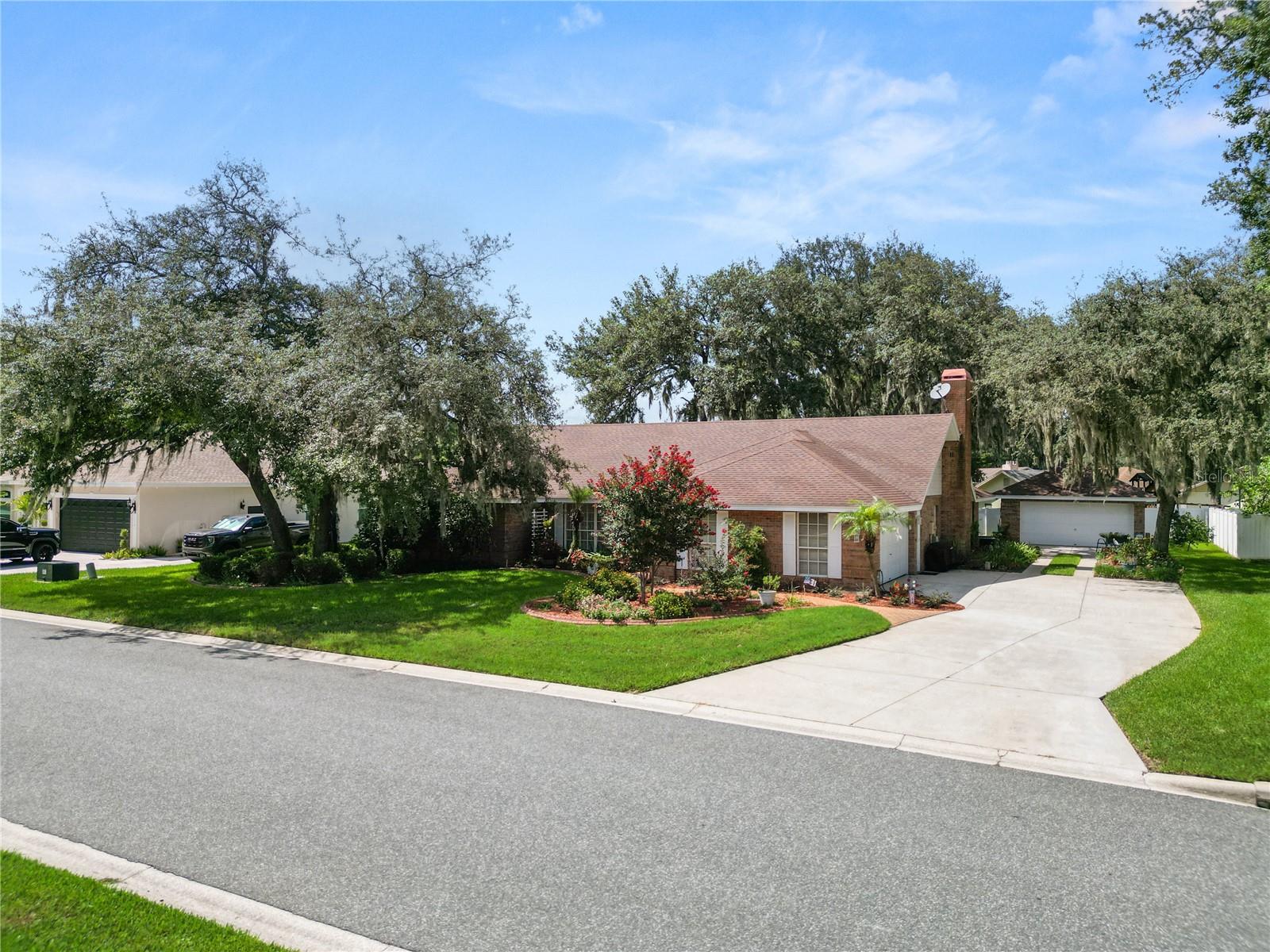 Welcome to timeless elegance in the highly sought after Sherwood Lakes community of North Lakeland! This beautifully maintained Ernie White built 3 bedroom, 2 bath traditional home blends classic craftsmanship with thoughtful modern updates, offering character, quality, and functionality that's increasingly hard to find. Inside, you'll appreciate spacious living areas highlighted by soaring vaulted ceilings with an exposed wood beam, a cozy wood burning fireplace, oversized bedrooms, and an abundance of custom built-ins throughout. Classic architectural details, including glass M-Tech door knobs, custom baseboards, and detailed door and window trim, add to the home's timeless appeal.

The well appointed kitchen is designed for both everyday living and entertaining, featuring stunning Saturnia Gold granite countertops, an under mount sink, pull out shelving in the cabinets and pantry, and a convenient serving bar that opens directly to the screened lanai. The spacious primary suite offers plenty of space with French doors that open to the screened lanai. The primary bathroom has been remodeled and features custom built ins, a dual sink vanity with under mount lighting, a large tiled walk in shower, soaking tub, dual walk-in closets, and a private water closet. Additionally, there is a dedicated craft room that provides the perfect space for hobbies, a home office, or creative projects.

Step outside to enjoy a backyard designed for both relaxation and entertaining. The screened lanai overlooks a mature, beautifully landscaped yard complete with established gardens, charming stepping stone pathways, a partially fenced yard, and peaceful pond views with no rear neighbors. Relax beneath the shade of majestic oak trees on the inviting wood deck sitting area, while the irrigation system and conveniently placed yard outlets make maintaining landscaping and seasonal lighting a breeze.

The attached 2 car garage includes a keyless entry and a laundry area with utility sink.
Car enthusiasts, hobbyists, and woodworkers will appreciate the exceptional detached two car garage featuring a ribbon driveway, pedestrian access door, built in cabinetry, workbench, utility sink, pegboard storage, sub-panel, three 220-volt outlets, a high-efficiency air filtration system that cycles and filters the air four times per hour, an operational exhaust fan, and garage doors reinforced to withstand winds up to 150 mph. 
Combining timeless architecture, exceptional craftsmanship, and an incredible list of custom features and workshop amenities, this one of a kind Sherwood Lakes home offers the perfect blend of classic charm and modern convenience in one of North Lakeland's most established communities.
