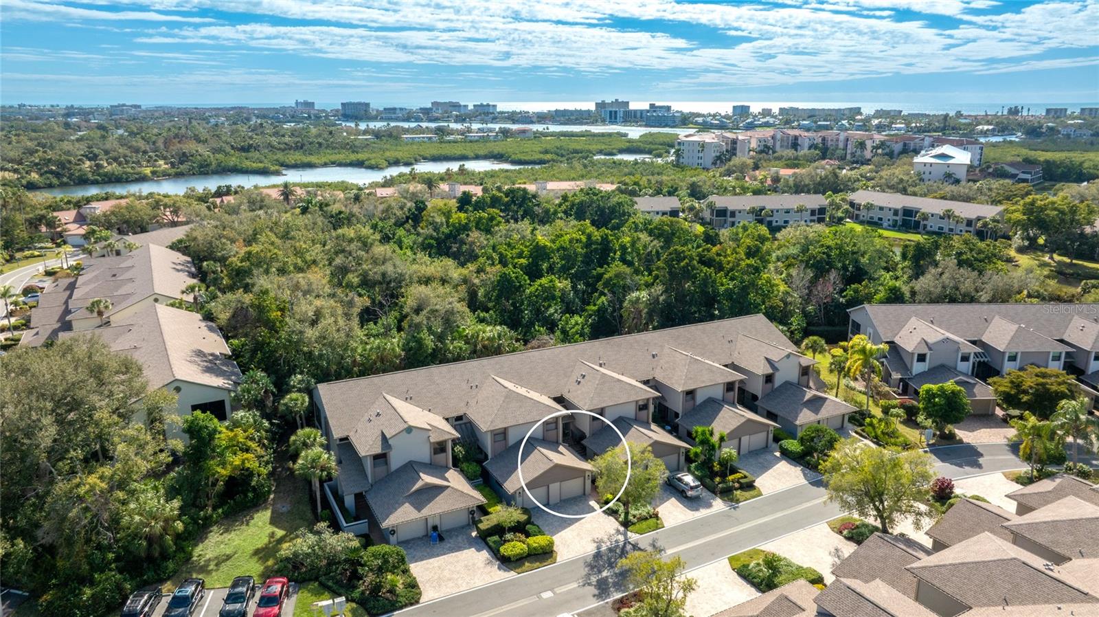 One or more photo(s) has been virtually staged. LET'S MAKE A DEAL! Take advantage of a $5,000 incentive at closing, yours to use as you choose toward a decorating or flooring allowance, HOA fees, or closing costs. Positioned as one of the best buys in The Landings, with arguably the best location and amenities the community offers, this beautifully maintained second-floor coach home delivers standout value. A brand new roof, gutters, AC, exterior paint, resurfaced roads, and a brand new community pool set the stage in The Landings, one of Sarasota's most established guard-gated communities. Tucked at the end of a private cul-de-sac just one block from the pool and community amenities, the setting offers privacy and convenience in equal measure, with the big-ticket items already handled. A private entry framed by distinctive tile steps opens to a light-filled interior where soaring vaulted ceilings give the space an immediate sense of openness. Wide-plank wood flooring runs through the main living areas, connecting each room with an easy flow while keeping the dining, living, and kitchen spaces nicely defined. Just off the living area, an enclosed lanai lined with expansive sliding glass doors looks out over peaceful treetops, a quiet spot equally suited to morning coffee or winding down in the evening. At the heart of the home, the kitchen balances function and warmth with white cabinetry, granite countertops, custom tile backsplash detailing, and a sunlit eat-in area. A breakfast bar opens to the living and dining rooms for effortless entertaining, while a built-in dry bar adds character, extra storage, and a natural spot to serve guests. The primary suite carries the same vaulted ceilings and includes a flexible alcove that works beautifully as a sitting area or home office, along with a dedicated dressing space, built-in storage, and an oversized walk-in closet. Its en-suite bath offers a walk-in shower with bench seating, generous counter space, and timeless finishes. Two additional bedrooms and a guest bath round out the layout, leaving room for visitors, hobbies, or a work-from-home setup. Life here is genuinely maintenance-free. The HOA covers the roof, windows, sliders, screens, exterior paint, landscaping, pest control, cable and Xfinity service, and insurance from the drywall out. The home sits approximately 21 feet above sea level and is not in a flood zone, an increasingly meaningful detail on the Gulf Coast. Residents of The Landings enjoy the Racquet Club with tennis and pickleball, resort-style and lap pools, a fitness center, clubhouse, and an active social calendar, plus a scenic nature trail leading to Roberts Bay, where a kayak launch and fishing dock offer direct access to the water. A private garage with attic storage, a paver driveway, and convenient guest parking complete this move-in-ready residence, close to the beaches, dining, and culture that define Gulf Coast life. Come experience the comfort and ease of The Landings for yourself. **THIS PROPERTY QUALIFIES FOR A 1% LENDER INCENTIVE IF USING PREFERRED LENDER. INQUIRE FOR MORE DETAILS.**