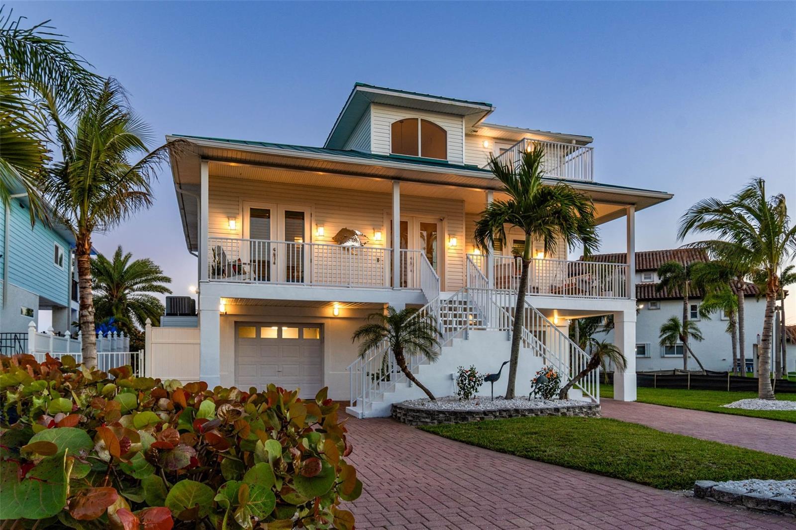 HUGE PRICE REDUCTION. YOUR GULF COAST DREAM HOME AWAITS!  Best-life living in paradise with EXPANSIVE WATER VIEWS and ONLY ONE MILE from world-famous white sand beaches and the most spectacular sunsets. Casual elegance meets coastal charm in this bright and airy custom-built home with soaring 20-foot ceilings and windows, providing unparalleled views of Boca Ciega Bay. Watch dolphins daily, visit with the manatees and fish off your dock in the calm and quiet waters.  No expense was spared for the newer DEEP WATER dock (2024) with composite decking, a 13,000 lb. boat lift, fresh water and electrical with plenty of room for power boats, sail boats, jet skis or your yacht. Take off from your dock and arrive at the open waters of the Gulf in just a few minutes! The island life awaits whether its biking to the beach, brunch by boat, sunset cruising, or deep-sea fishing. You will never lack for entertainment and adventure with fine dining, tiki bars, live music, vibrant nightlife, and shopping. Launch your kayaks and paddle the multitude of mangroves, tiny islands and bird sanctuaries, or explore the endless variety of parks - all just minutes from your dock and door.  Hang out at home while you swing and snooze in the hammock under the palms while enjoying the cooling sea breezes. Lounge by your crystal-clear pool and work on your tan, and then unwind under the stars in your jetted hot tub while watching the crackling flames of your firepit. The good life is yours in the bright and sprawling open concept kitchen/dining/living area that is perfect for entertaining.  Gleaming granite countertops, countless cabinets, a huge island and an enormous floor to ceiling pantry are a chef’s dream!  Impress guests with your water views, backlit wet bar and wine fridge, and WOW the crowd with the annual Madeira Beach Holiday Lighted Boat Parade cruising by!  Three spacious spare bedrooms with 2 full baths provide lots of options, and your guests can even enjoy complete privacy in an enclosed 2-room guest suite with a full bath and its own entrance. After a day of entertaining, escape to ultimate relaxation in your private owner’s suite on its own floor, boasting his and hers walk-in “California” closets and a massive bath complete with a balcony! Slow down, sip a cocktail and soak while enjoying the sunset and painted sky from your oversized jetted garden tub.  You can even view the sunset from your massive tiled shower with a large bench and 3 shower heads!  Wake up and enjoy sunrise coffee and water views from your bed or sitting on your bay-side bedroom balcony.  Or enjoy the stunning birds eye views of the bay  and even downtown St. Pete - from the unique owner’s suite loft. Lower level features and oversized garage with room for 4 cars and a ton of storage. Your new home is located on a quiet, dead-end street.The peaceful, walkable neighborhood is surrounded by the bay and has several parks and NO HOA FEES. Other features of your new home include 10-foot ceilings, custom-etched glass doors and windows by local artist,  laundry room on the main floor, complete with water views, a private pool-side outdoor shower (with hot water!), a whole-house water softener, expansive front and back decks, large attached potting/storage shed, and a safe/secure grassy side yard FOR YOUR PETS. Stop dreaming and START LIVING