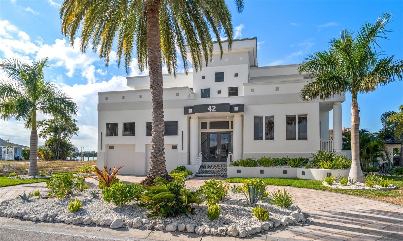 Experience the pinnacle of luxury waterfront living at 42 Midway, an exceptional residence located in the exclusive Island Estates community of Clearwater Beach. Combining an unbeatable location with direct Gulf access, a private dock and boat lift, resort-style amenities, and unparalleled privacy, this extraordinary property delivers the coastal lifestyle discerning buyers dream about.
Encompassing 4,944 square feet, this beautifully designed four-bedroom, three-and-a-half-bath home showcases timeless architecture, elegant finishes, and breathtaking panoramic water views from nearly every room. Expansive walls of glass and soaring ceilings flood the interiors with natural light, creating an atmosphere that is both sophisticated and inviting.

The thoughtfully designed open floor plan seamlessly blends formal and casual living spaces, making it equally suited for grand-scale entertaining or comfortable everyday living. At the heart of the home, the gourmet chef's kitchen features premium appliances, custom cabinetry, luxurious finishes, and generous prep space, all while remaining connected to the surrounding living and dining areas.
Step outside to discover your own private waterfront oasis. Surrounded by lush tropical landscaping, the expansive outdoor living area features a resort-style pool and spa, a fully equipped outdoor kitchen, and multiple spaces to relax or entertain. Your private dock with boat lift offers immediate access to the Intracoastal Waterway and the Gulf of Mexico, placing world-class boating, fishing, waterfront dining, and unforgettable sunsets just moments from your backyard. Every detail of this exceptional home has been designed to embrace Florida's indoor-outdoor lifestyle while offering the comfort, elegance, and exclusivity that define luxury waterfront living. Whether you're hosting family and friends, spending the day on the water, or simply enjoying the peaceful surroundings, 42 Midway offers an extraordinary opportunity to own one of Clearwater Beach's premier waterfront residences. This is more than a home—it's a destination, a lifestyle, and a rare opportunity to experience the very best of coastal luxury.