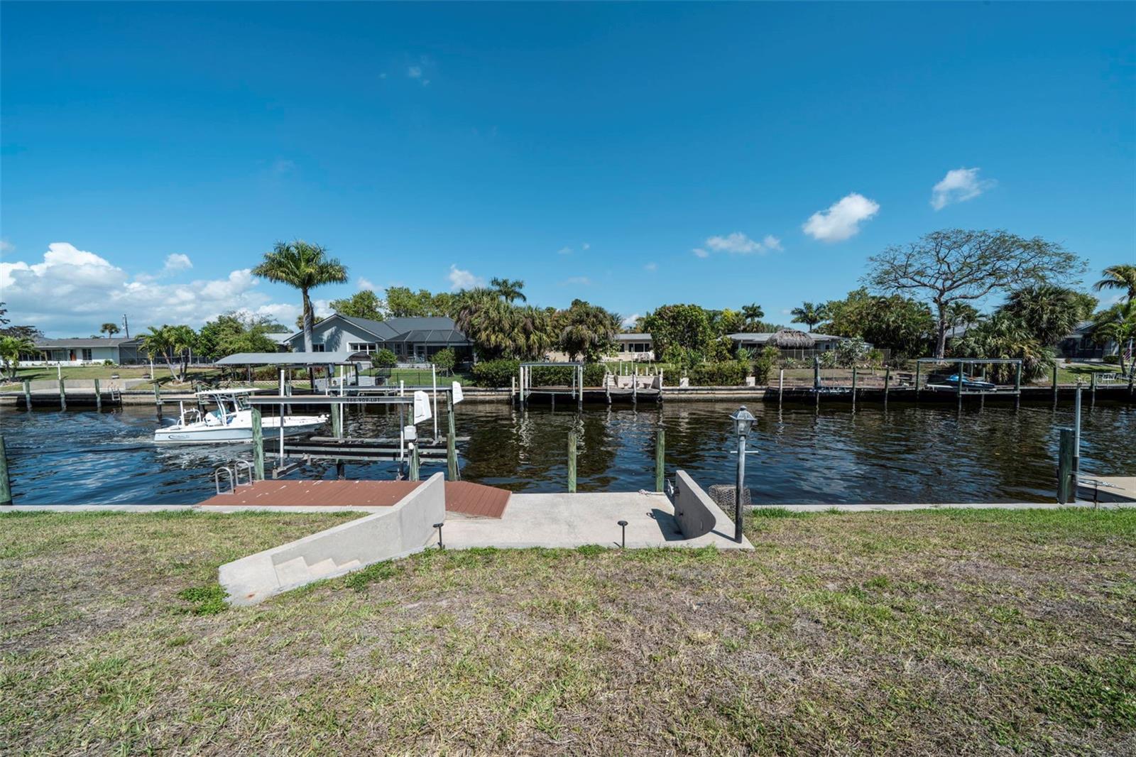 Virtually Staged. Gulf Access Pool Home on the Lido Canal. Mid-century modern meets contemporary coastal at this gulf access pool home with 7,000 lb boat lift and dock. Currently an Airbnb Guest favorite with a whopping 4.93 Star Rating. Jump right into Airbnb hosting or make this your next home. The home features a desirable split floorplan which offers privacy for your guest and family. Primary suite includes dual closets with a large updated ensuite primary bath, a tranquil retreat - featuring both a large walk-in shower and deep luxurious soaking tub. This home was truly designed with you in mind. Everything from the colorful joyful colors in the bedrooms to the tranquil modern dinning room. Comfy sofa and multiple lounge areas. Kitchen has stainless steel appliances, wooden cabinetry & granite counter tops. Guest bath has been stylishly renovated within the last 3 years. Rounding out this home is 2 car garage and includes washer and dryer. Outdoors, enjoy the expansive screened lanai overlooking the solar-heated pool and serene canal that goes out to the gulf with only one bridge along the way. The City of Cape Coral with its many canals, parks & great restaurants, is rapidly growing, offering new opportunities and developments, making it a top place to live, work, and visit in Florida.