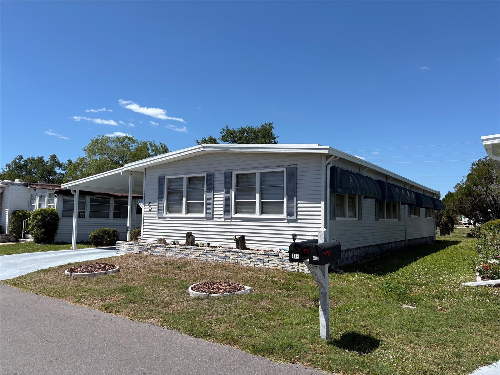 Looking for a  55+ mobile home community with lots of activities and amenities? Venice Isle, just off US41, is the place for you. This double wide manufactured home is located on a quiet street and has a nice backyard which many of these homes do not. The Carport is brand new as of early 2025. It houses a lanai area which can be screened in, as well as, a shed which contains a washer/dryer, workbench, and lots of tools. The home has a brand new Carport, newer plumbing, newer roof-over, new flooring, newer bathrooms, and updated kitchen.  You can enter the home through the first door which leads you to the kitchen and what was the original Florida Room, or you can enter further down to a door that leads you to the dining room and kitchen. Spacious kitchen with lots of white soft-close cabinets. It includes a dishwasher, stove/range with microwave, refrigerator and cute window above the sink and a sun tunnel above. Counters are solid-surface white with a bar area for parties or a quick bite. Next to the kitchen as you enter is the dining room with a built-in display cabinet and a sun tunnel between the kitchen and dining room.  Beyond the dining room is the living room which has been extended by the enclosed Florida Room. Windows in the Public area have lovely custom shades which provide privacy but also filtered light. Flooring is vinyl throughout and both bathrooms have been updated. All furniture conveys, however, there is no bed in the Primary Bedroom. Seller is leaving 3 televisions, furniture, and household items. This home is ready for you to make it your own. This property is located in a No Dog section of Venice Isle; however, 2 cats are permitted. If your not busy at the pool or doing other of the many activities  in Venice Isle, you can go to downtown historic Venice which is about 15 minutes away. Going the other direction on US41, you can head to Wellen Park with its 80-acre Grand Lake and nature trails. Cool Today Park with the Atlanta Braves Spring Training Stadium is just 5 minutes from Wellen Park. Enjoy Spring Training and other events there throughout the year. Of course, you have the many Gulf beaches which are are a short drive away. The Sarasota Memorial Hospital, Venice Campus, is just 20 minutes away as well.