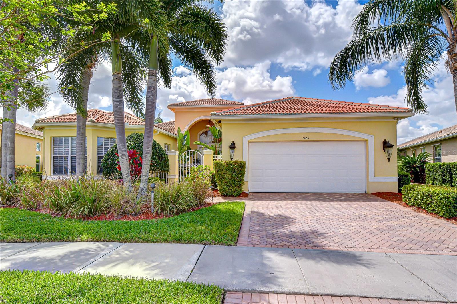 Welcome to resort-style living in the highly sought-after Valencia Lakes—a premier gated 55+ community known for its vibrant lifestyle and exceptional amenities. Perfectly positioned on a rare pie-shaped, south-facing waterfront lot, this home offers breathtaking lake views while overlooking the community center. The unique orientation provides the best of both worlds—sun-drenched pool and lanai areas all day, while the home itself stays naturally cooler with minimal direct sun exposure. From the moment you arrive, you’ll appreciate the beautiful tile roof, pavered driveway, and inviting tropical courtyard entry that sets the tone for what’s inside. Step through the front door and your eyes are immediately drawn to the expansive water views and the stunning lanai featuring a sport-style pool, creating the ultimate indoor-outdoor Florida lifestyle. This thoughtfully designed 2-bedroom, 2.5-bath + den residence offers a split floor plan that ensures privacy for both owners and guests, while the open-concept layout is ideal for entertaining. The home is enhanced with high-end finishes throughout, including triple tray ceilings, crown molding, upgraded lighting, and custom built-ins. At the heart of the home is the spacious kitchen, seamlessly connecting to the formal dining and great room. Features include upgraded cabinetry with custom pull-out drawers, built-in double oven, and a bright breakfast nook with serene lake views—the perfect place to start your day. Step outside to the lanai where a propane grill hookup makes outdoor cooking effortless. The private primary suite is tucked away for maximum tranquility and showcases stunning lake views, direct lanai access, and dual custom walk-in closets. The en-suite bath is generously sized with separate vanities, a dedicated makeup vanity, and full-length mirrors spanning the wall. On the opposite side of the home, the guest suite offers its own en-suite bath, providing comfort and privacy for visitors. The versatile den is ideal as a home office, fitness room, or optional third bedroom. The community center also features a wonderful on-site café offering breakfast, lunch, and dinner, along with special menus for holidays and events, adding to the ease and enjoyment of everyday living. Valencia Lakes isn’t just a community—it’s a lifestyle. Enjoy a 40-acre waterfront recreation area, resort-style pools, a 40,000 sq. ft. clubhouse, tennis and pickleball courts, bocce, basketball, a fully equipped fitness center, dog park, baseball field, community garden, and RV/boat storage. Over 100 acres of nature preserves provide peaceful views, abundant wildlife, and a true sense of serenity. With hundreds of clubs and activities, friendly neighbors, and convenient access to Tampa, St. Petersburg, Sarasota, shopping, golf, and the airport, this home offers both comfort and convenience. This is more than just a home—it’s a premium lot, exceptional orientation, and lifestyle opportunity in one of the area’s most desirable communities.