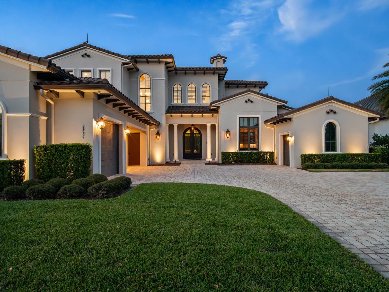 Welcome to this exquisite custom-built estate, perfectly situated in the prestigious Lake Nona Golf & Country Club, close to all of the Club’s member amenities and lake access. Built by DeVoe Custom Homes in 2017, this masterpiece offers 5 bedrooms, 5 full and 2 half baths, blending timeless elegance with modern sophistication.
Step inside to an expansive family room featuring soaring ceilings, intricate millwork, and 10-foot sliding glass doors that frame breathtaking views of the saltwater pool and serene pond. The open-concept design flows seamlessly into a chef’s kitchen equipped with top-tier appliances, a hidden walk-in pantry, and refined finishes throughout.
The luxurious owner’s suite is a private retreat, boasting a spa-inspired bath with a soaking tub, walk-in shower, dual vanities, and a custom-designed closet. The first floor also includes a secondary ensuite bedroom, a dedicated office, a concealed walk-in wine cellar, and a newly converted, air conditioned indoor/outdoor Florida room—perfect for year-round enjoyment.
Upstairs, discover three additional ensuite bedrooms, including a hidden fifth bedroom accessed through a secret bookcase door, adding a touch of intrigue and charm. 
Outdoors, indulge in resort-style living with a spectacular saltwater pool, spa, and outdoor grill, ideal for entertaining or unwinding under the stars. The oversized three-car garage and separate golf cart garage provide ample space for vehicles and hobbies.
Additional Features Include:  Control4 Automation, Home Organization Room, First and Second Floor Laundry