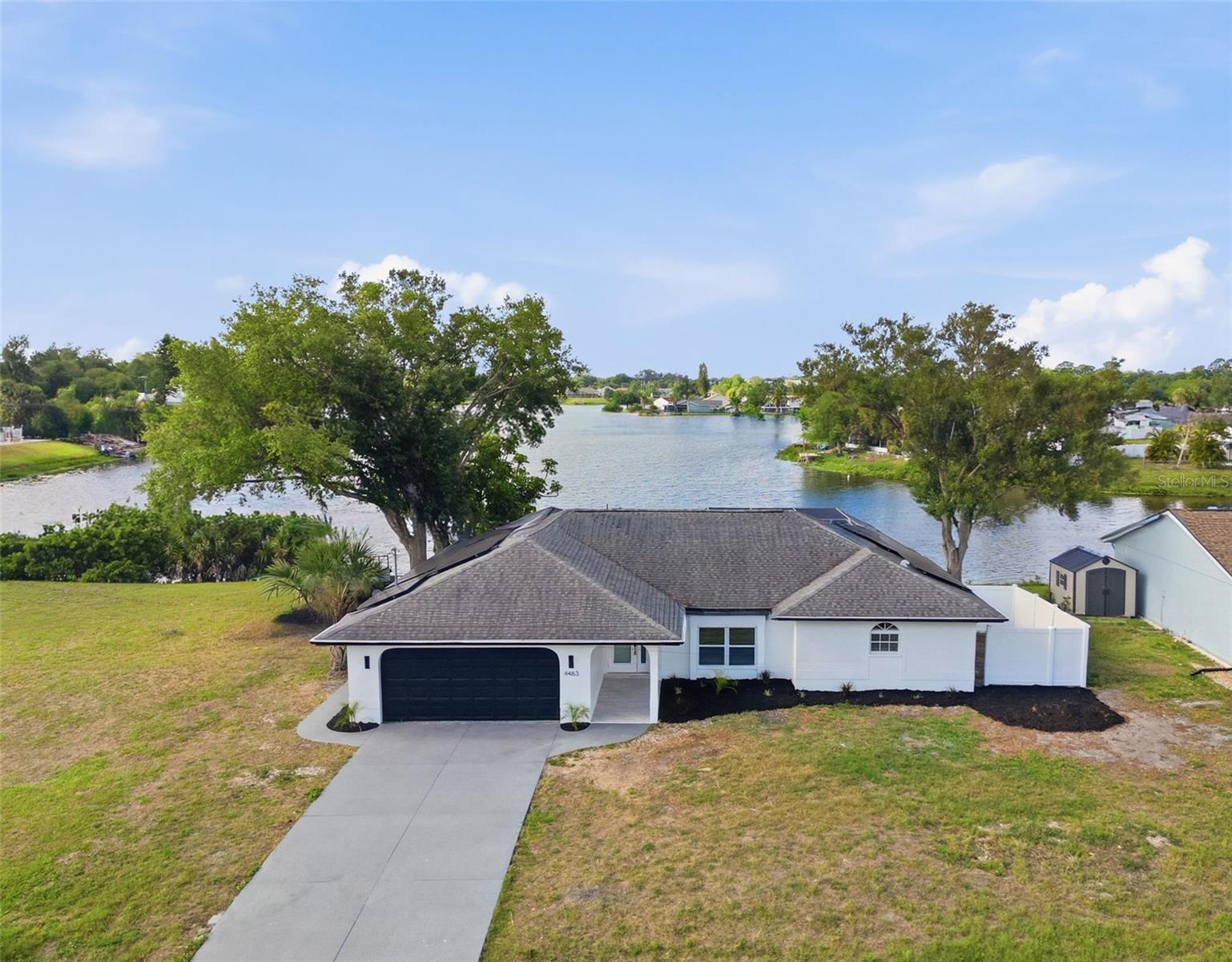 3 Bed | 2 Bath | 1,663 SqFt | 2-Car Garage | LAKEFRONT with Private Custom Dock

Welcome to this stunning, fully renovated lakefront pool home in the heart of North Port — a rare opportunity to own true waterfront living with modern luxury finishes, PAID-OFF SOLAR, NO FLOOD ZONE, and CITY WATER. Sitting directly on a peaceful freshwater lake with your own brand-new custom-built composite dock, this turn-key 3-bedroom, 2-bath home delivers the Florida lifestyle most buyers only dream of — without the typical waterfront headaches.

Step inside through the welcoming covered entryway to discover an open-concept floor plan with soaring vaulted ceilings, brand-new wood-look tile flooring throughout, designer light fixtures, and walls of natural light showcasing lake views from nearly every room. The chef's kitchen is the showstopper — featuring a stunning marble-look quartz island, custom white shaker cabinetry, full-height marble backsplash, brand-new stainless steel appliances, modern pendant lighting, and an oversized breakfast bar perfect for entertaining. The thoughtful layout offers both an island workspace and a separate prep area with farmhouse sink overlooking the lake.

The spacious primary suite offers serene water views and a fully remodeled spa-style en-suite with double marble vanity, designer LED-lit mirror, and a sleek frameless glass walk-in shower with floor-to-ceiling tile. Two additional bedrooms share a beautifully updated guest bathroom.

Step outside to your private resort:

Screened-in pool and spa with elegant blue tile accents
Brand-new built-in outdoor kitchen with stainless NXR grill and granite countertops — perfect for waterfront entertaining
Tiled outdoor pool shower for easy rinse-offs
Expansive covered lanai with multiple ceiling fans overlooking the pool and lake
Brand-new custom-built composite dock with generous space — ideal for fishing, kayaking, paddleboarding, lounging, or watching incredible Florida sunsets
Additional waterfront deck area with hammock and lounge space
Mature shade trees and unobstructed wide-open lake views
Major updates and key features:

PAID-OFF SOLAR PANEL SYSTEM — massive monthly savings, no lease, no loan
NOT IN A FLOOD ZONE — peace of mind plus lower insurance costs
CITY WATER — no well maintenance
AC system (2023) — newer, efficient, ready for Florida summers
Updated electrical panel and plumbing
Majority impact windows for storm protection and energy efficiency
Fresh interior and exterior paint
New landscaping
Enjoy the freedom of NO HOA, NO CDD, and NO deed restrictions — bring your boat, RV, kayaks, and toys.